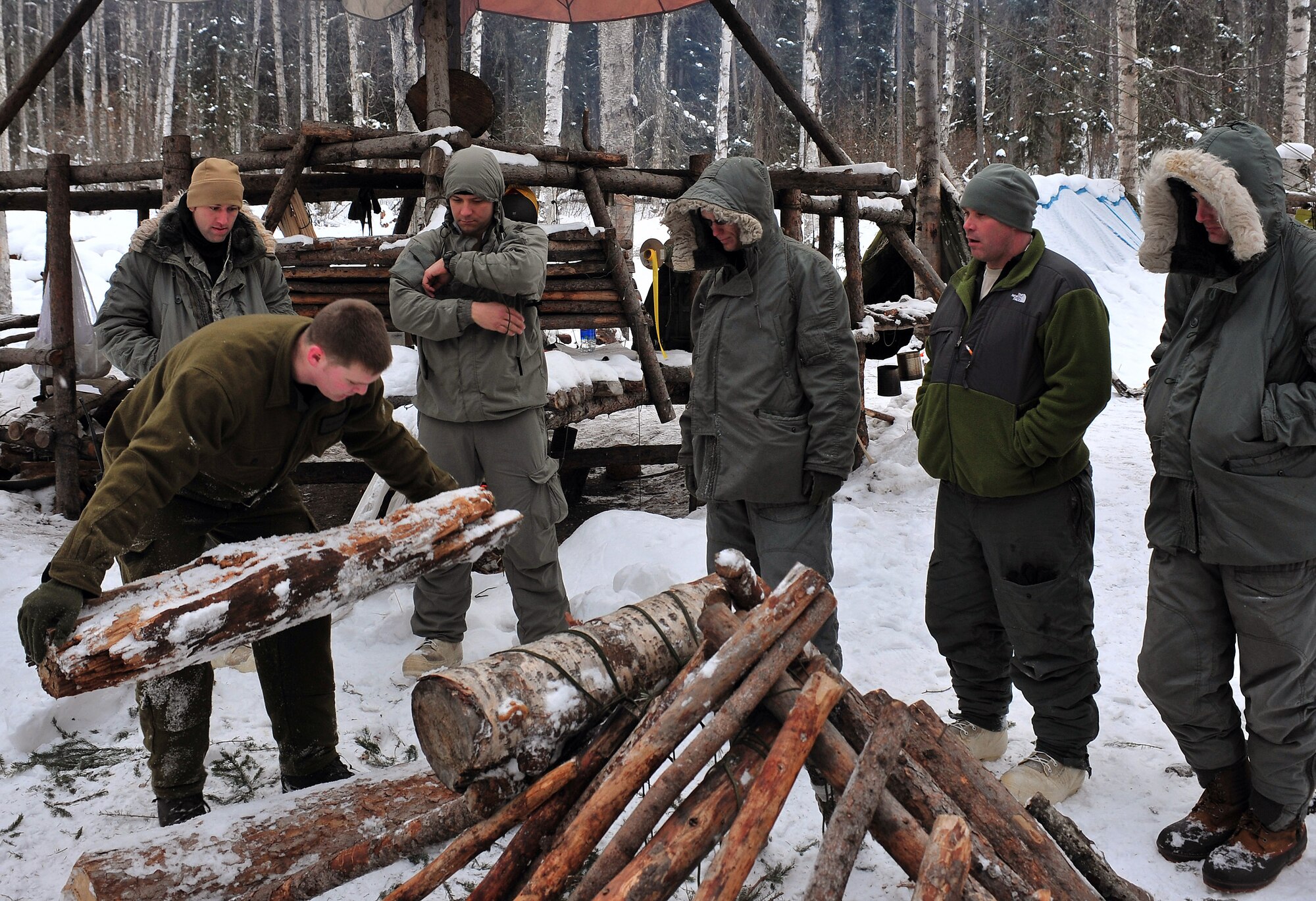 Senior Airman Jess Evans teaches a class how to choose and place kick-logs Feb. 25 at Eielson Air Force Base, Alaska. Kick-logs are used to fill the space between the earth and the area a door plug would fill on a thermalized A-frame. Airman Evans is an Arctic Survival School instructor. (U.S. Air Force photo/Airman 1st Class Willard E. Grande II) 

