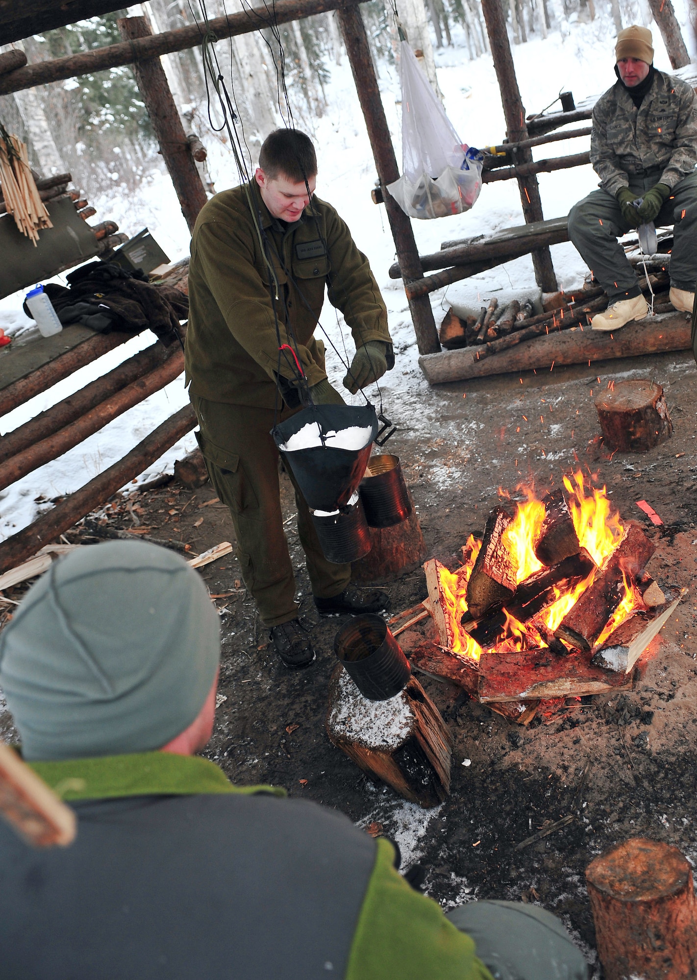 Senior Airman Jess Evans demontrates a water machine to a class attending Arctic Survival School Feb. 25 at Eielson Air Force Base, Alaska. A water machine is created by melting snow in a sea anchor of other improvized device and then water is collected in a container. Airman Evans is an Arctic Survival School instructor. (U.S. Air Force photo/Airman 1st Class Willard E. Grande II)