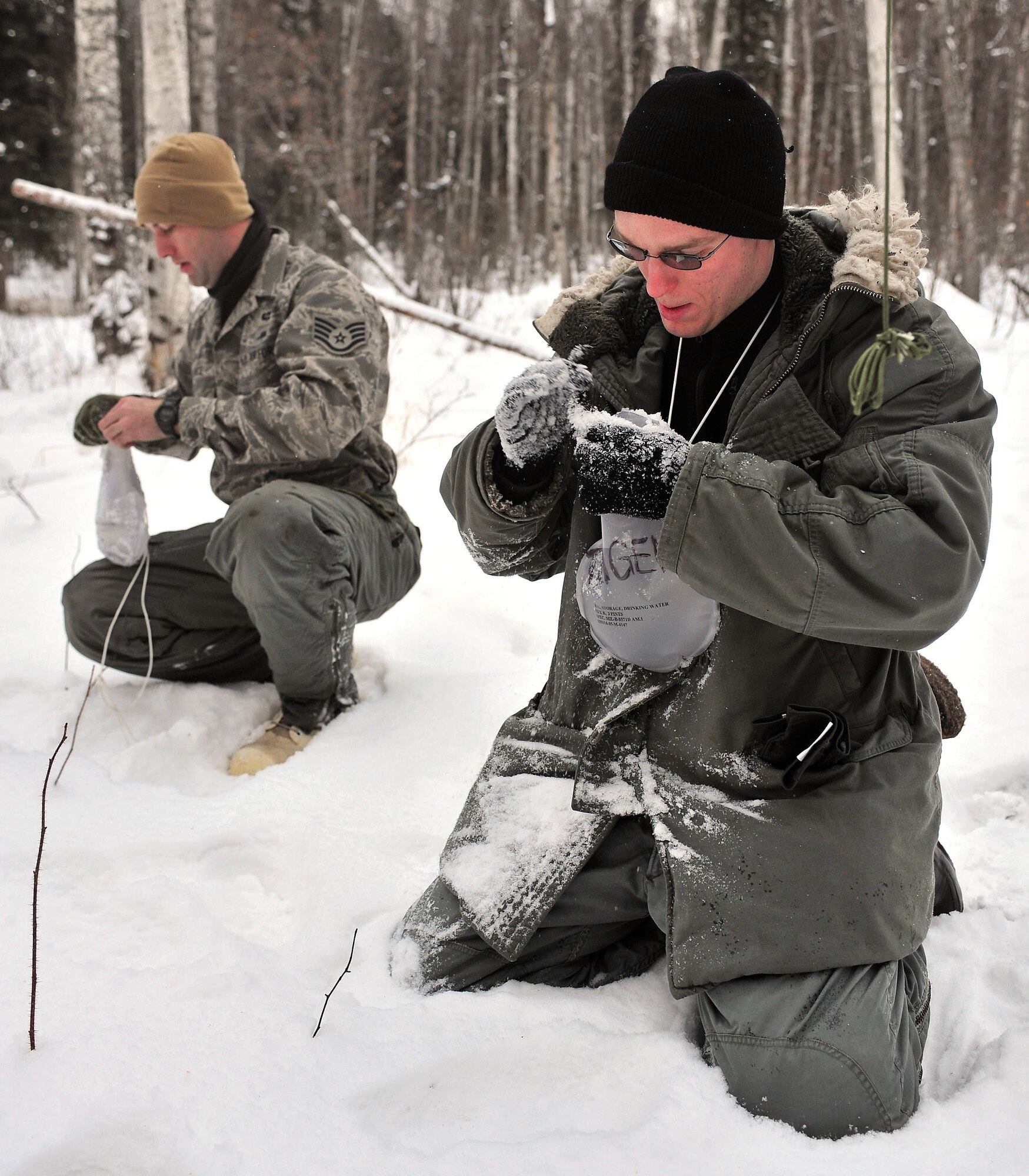 Airmen attending Arctic Survival School fill their water bottles with snow Feb. 25 at Eielson Air Force Base, Alaska. Body heat will melt the snow, providing a perpetual water source. (U.S. Air Force photo/Airman 1st Class Willard E. Grande II) 
