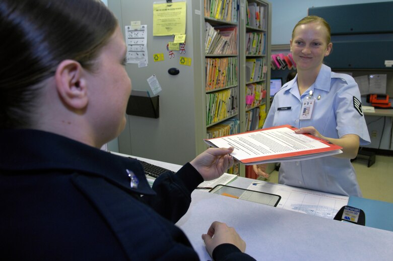 VANDENBERG AIR FORCE BASE, Calif. -- Senior Airman Shawna Holbrook, 381st Training Squadron cyber systems technician, receives medical records from Staff Sgt. Nikki Favors, 30th Medical Operations Squadron dental assistant, here March 2. (U.S. Air Force photo/Airman 1st Class Andrew Lee) 