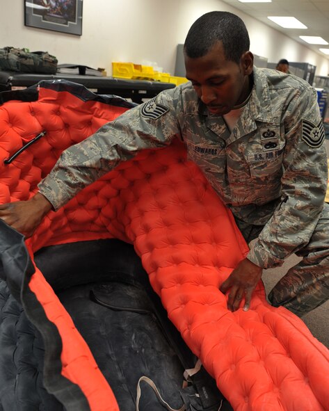 MOODY AIR FORCE BASE, Ga. -- Tech. Sgt. David Edwards, 347th Operations Support Squadron, NCO in-charge of aircrew flight equipment, opens an inflated single man survival raft to show reporters from the Valdosta Daily Times how the system works here March 3. Sergeant Edwards described nine additional types of inflatable survival rafts that are carried on three different air craft types stationed here at Moody. (U.S. Air Force photo by Senior Airman Javier Cruz Jr.)