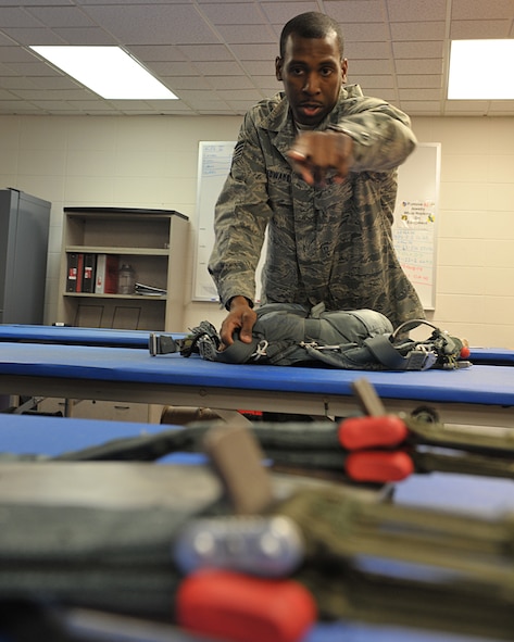 MOODY AIR FORCE BASE, Ga. -- Tech. Sgt. David Edwards, 347th Operations Support Squadron, NCO in-charge of aircrew flight equipment, points out the innards of a packed parachute to reporters of the Valdosta Daily Times, here March 3. Sergeant Edwards supervises the packing of parachutes used on all Moody aircraft and ensures all inflatable survival rafts are functional as well. (U.S. Air Force photo by Senior Airman Javier Cruz Jr.)