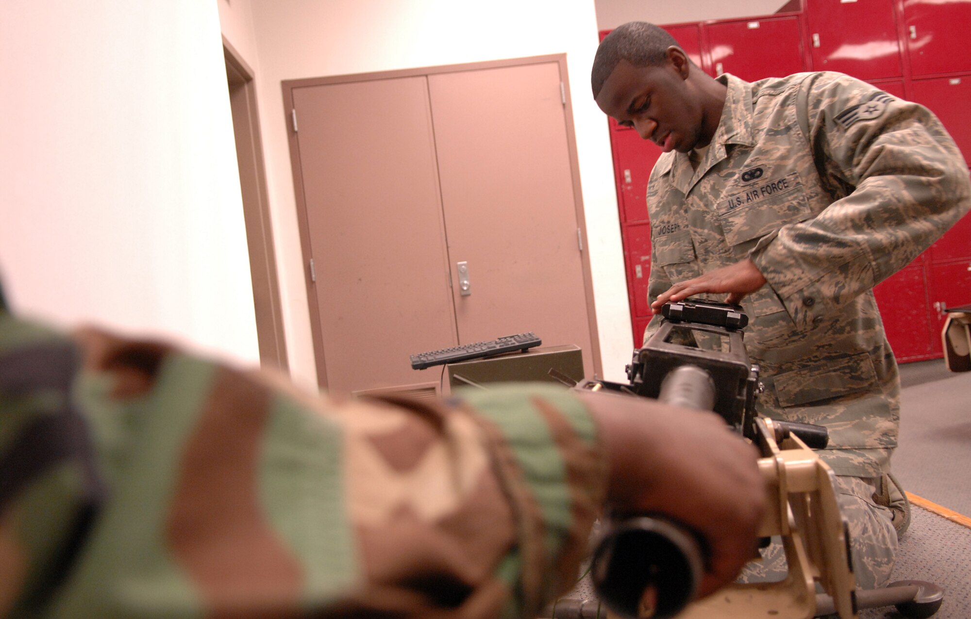 WHITEMAN AIR FORCE BASE, Mo. – Senior Airman Kashara Joseph, 509th Security Forces Squadron, checks a MK-19 while Senior Airman James Bovain, 509th SFS, holds it steady during familiarization training Feb. 27. The MK-19 Automatic Grenade Launcher or Machine Gun is a self powered, air-cooled, belt-fed, blowback operated, crew-served weapon. (U.S. Air Force photo/Senior Airman Stephen Linch)