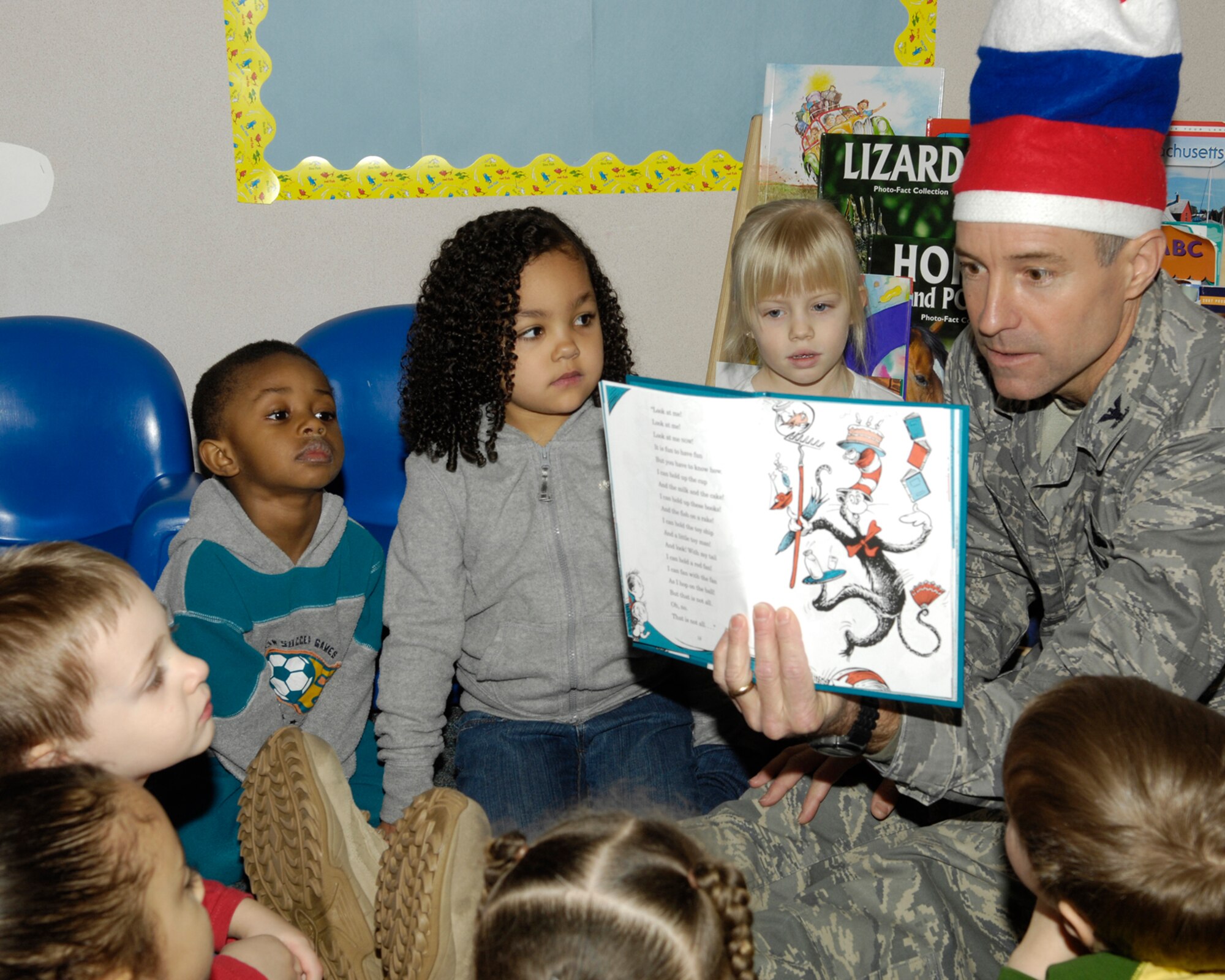 HANSCOM AIR FORCE BASE, Mass. – Children at the Child Development Center gather around Col. David Orr, 66th Air Base Wing commander, as he reads  the Dr. Seuss book, "The Cat in the Hat",on March 2 . The CDC is hosting guest readers throughout the week to highlight the importance of reading to children in celebration of the nationwide Read Across America campaign. (U.S. Air Force photo by Linda LaBonte Britt)