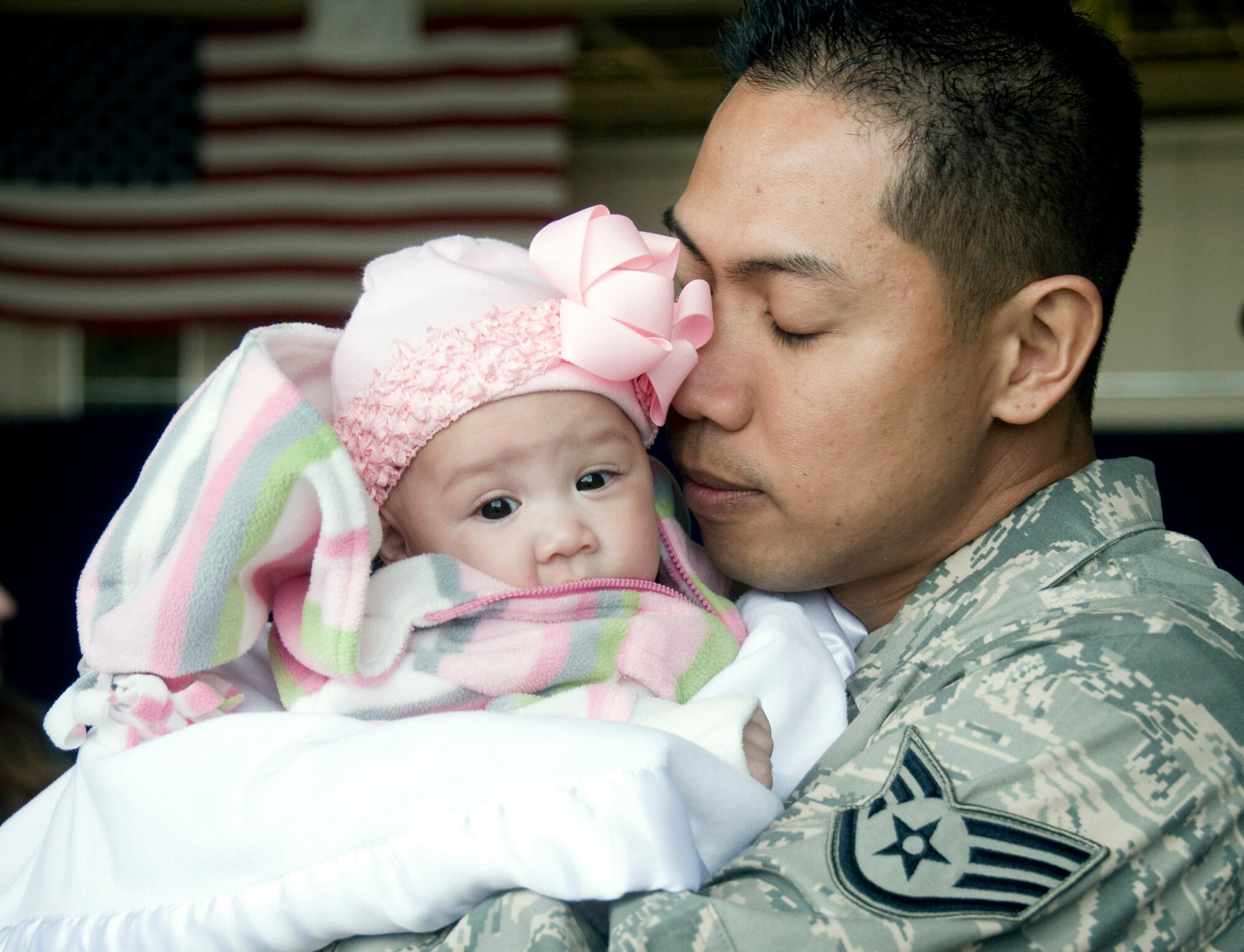 Staff Sgt. Dennis Horlador embraces his newborn, Natyala, after returning March 1 to Misawa Air Base, Japan. Sergeant Horlador, assigned to the 35th Operations Group, missed the birth of his daughter while deployed to Joint Base Balad, Iraq. (U.S. Air Force photo/Staff Sgt. Rachel Martinez) 
