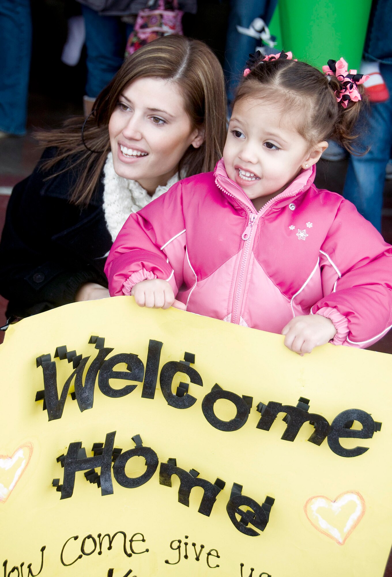 Jill and Jada Banks await the arrival of Senior Airman Corey Banks March 1 at Misawa Air Base, Japan. Airman Banks was one about 300 Airmen to return to Misawa AB following a deployment to Joint Base Balad, Iraq. (U.S. Air Force photo/Staff Sgt. Rachel Martinez) 
