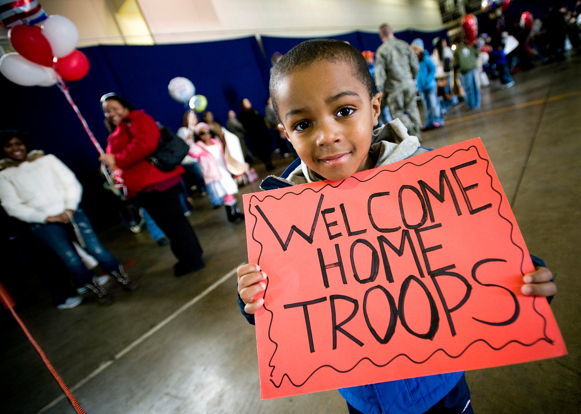 John Parker Jr. displays a sign celebrating his father's return March 1 at Misawa Air Base, Japan. John waited with many other base members for the passenger airplane bringing friends and families home. John and his family are from Houston. (U.S. Air Force photo/Staff Sgt. Samuel Morse) 
