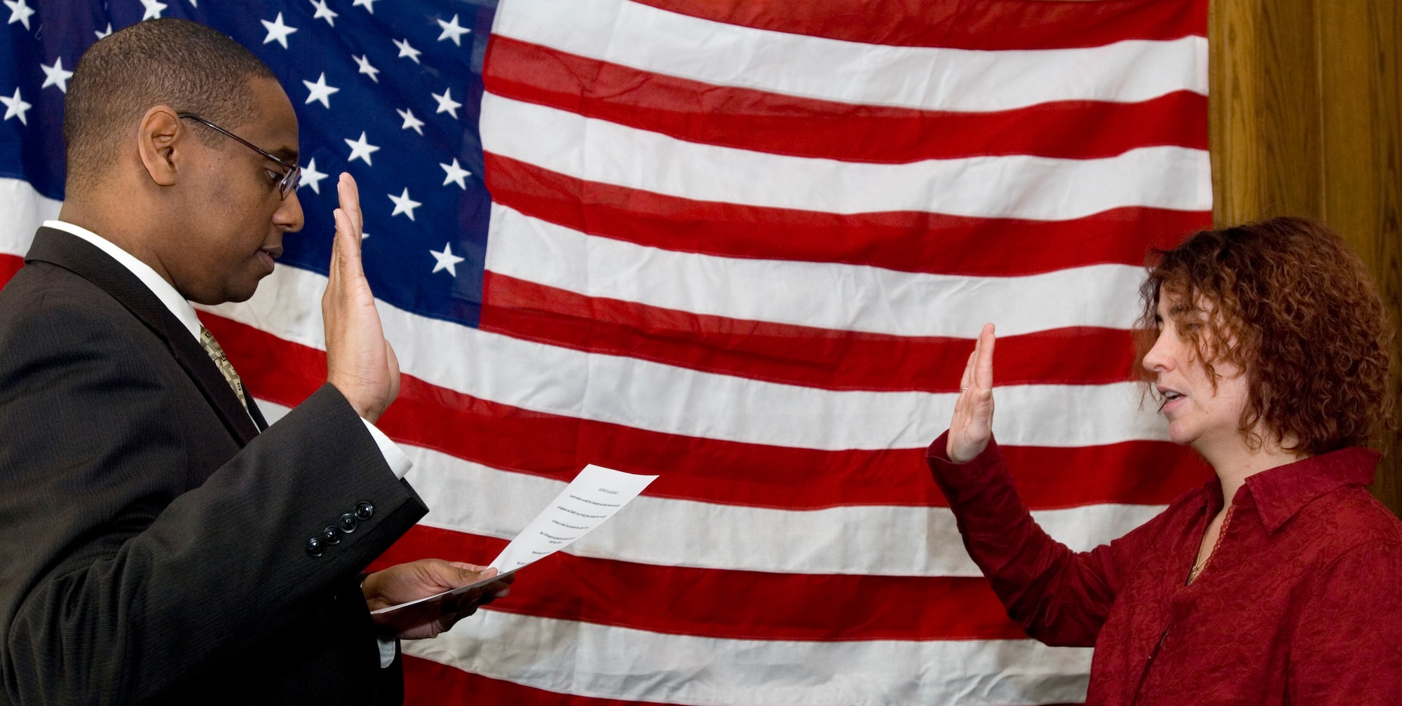 Kirsten Villamor, right, recites the oath of allegiance with U.S. Citizenship and Immigration Services Field Office Director Elliott Cook, at Middleton Hall, Feb. 13, 2009. Mrs. Villamor is the first military spouse to become a naturalized U.S. citizen while physically located RAF Mildenhall, England, and only the second military spouse to become an American citizen while on U.K. soil. The law allowing military spouses to be naturalized at the military member’s overseas location changed  in January, 2008, (U.S. Air Force photo by Master Sgt. Tracy L. DeMarco)