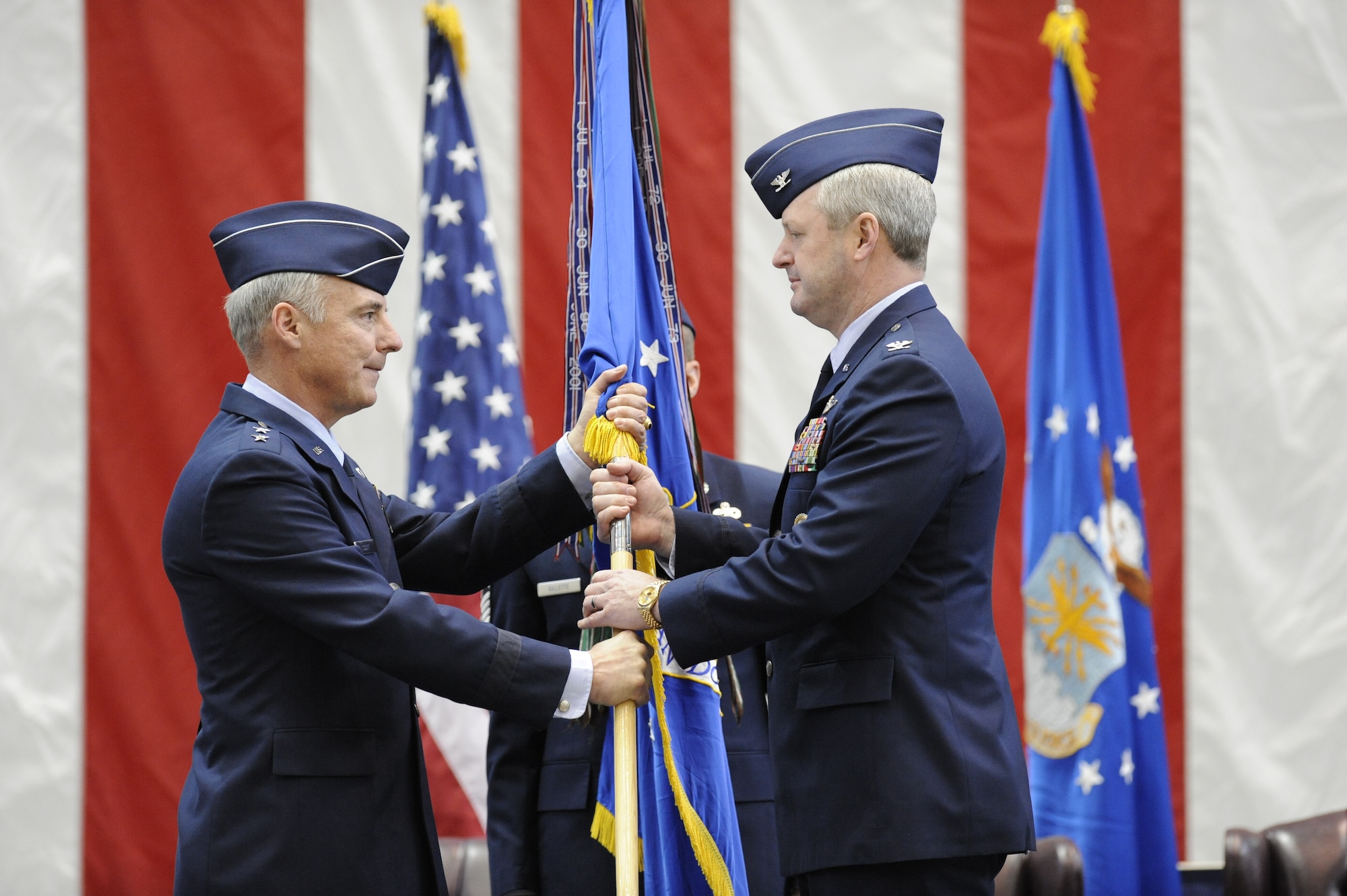 Maj. Gen. Winfield Scott III, 18th Air Force commander, passes the wing flag to Col. Scott Smith, the new 305th Air Mobility Wing commander, during an assumption of command ceremony here March 3. Colonel Smith was formerly the 305th AMW vice commander. (U.S. Air Force photo/Carlos Cintron)