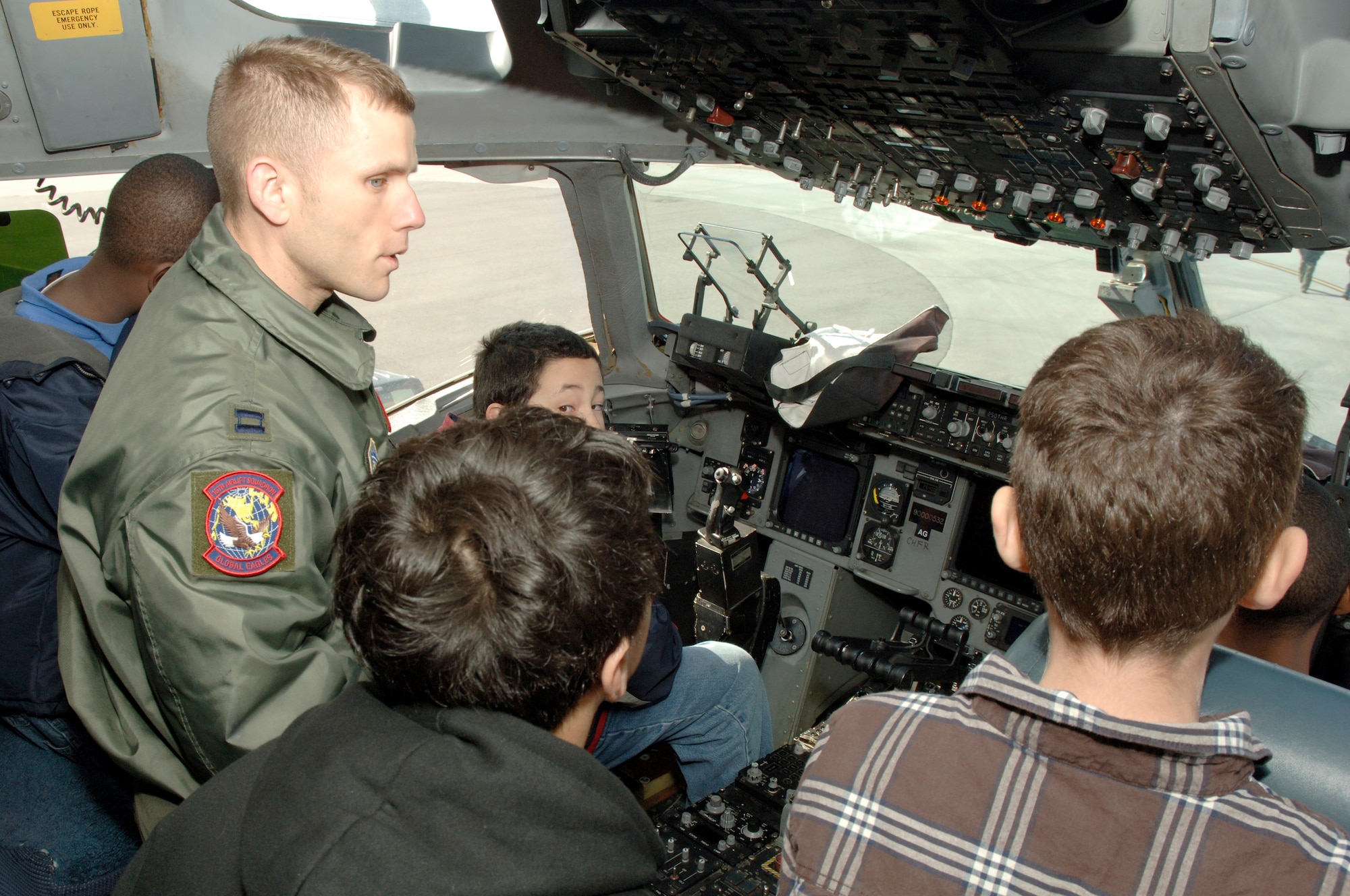 Capt. Robert Hardenstine explains some basic operation of various switches and buttons in the cockpit during a tour of a static C-17 on the flightline here March 3. Students from Devon Forest Elementary school in Goose Creek, S.C. were given the opportunity to take part in this field trip to inspire them to succeed and realize that they can achieve personal goals if they work hard towards accomplishing them. Captain Hardenstine is a wing tactics pilot assigned to the 437th Operations Support Squadron. (U.S. Air Force photo/Staff Sgt. Marie Cassetty)
