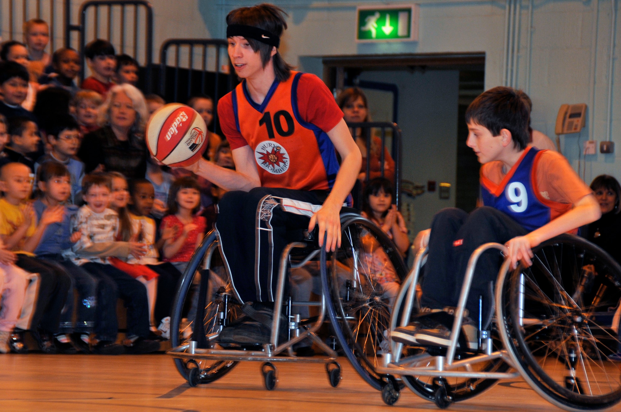 Alex Walls chases down Aiden Hughes during a wheelchair basketball game Feb.19 at Lakenheath Elementary School. The Bury Bombers are a wheelchair basketball team that allows disabled and able-bodied the opportunity to learn the game of wheelchair basketball. (U.S. Air Force photo by Airman 1st Class Perry Aston) 