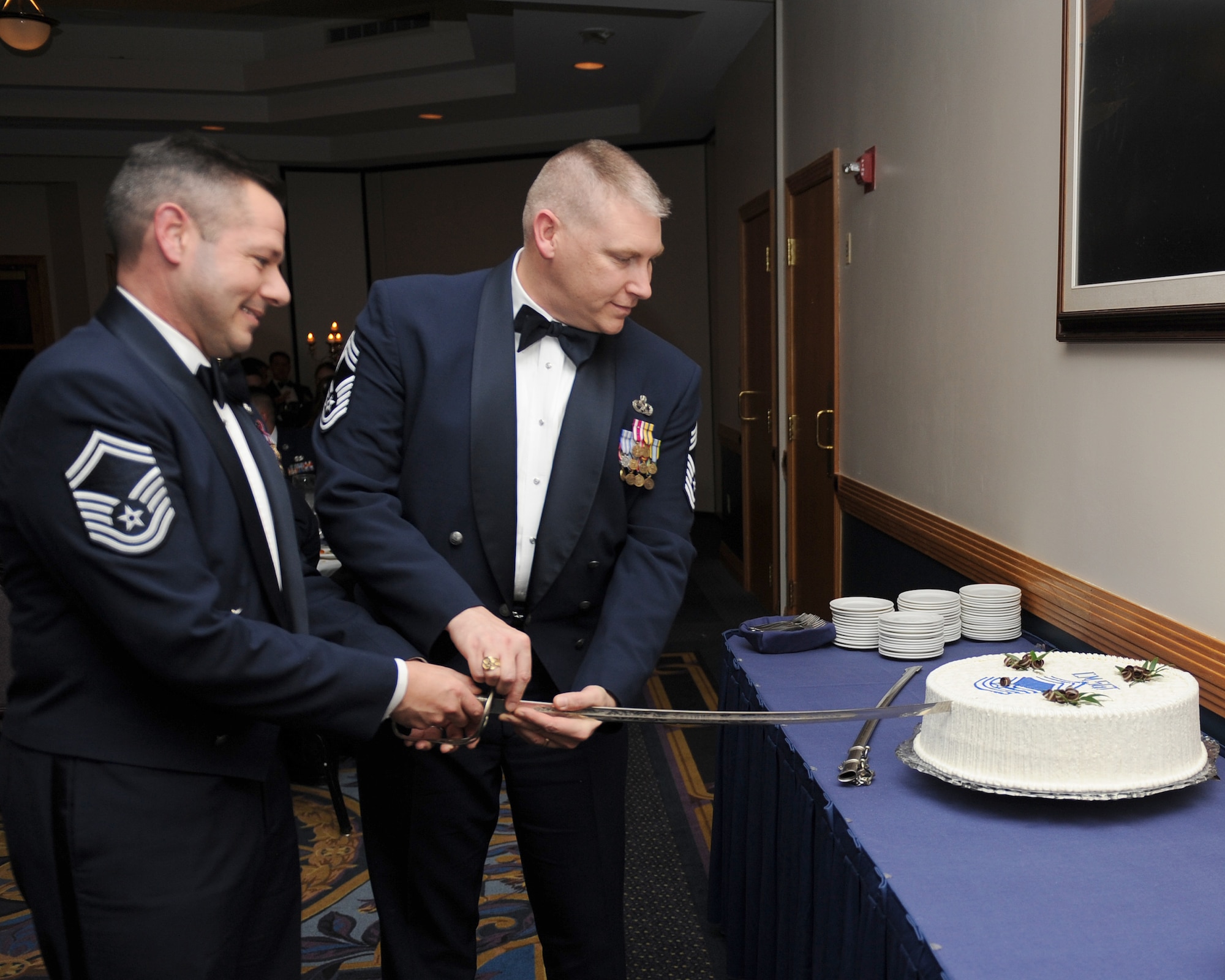 It’s a celebration!  Chief Master Sgt. Andrew Bauer, 509th Maintenance Group superintendent and Senior Master Sgt. Michael Santillo, 509th Communications Squadron superintendent slice a cake with a saber during the Chief Master Sergeant Recognition ceremony Feb. 27 at the Missions End.  Ten of Team Whiteman’s senior non-commissioned officers were recognized for promotion to the highest enlisted rank during the ceremony. 