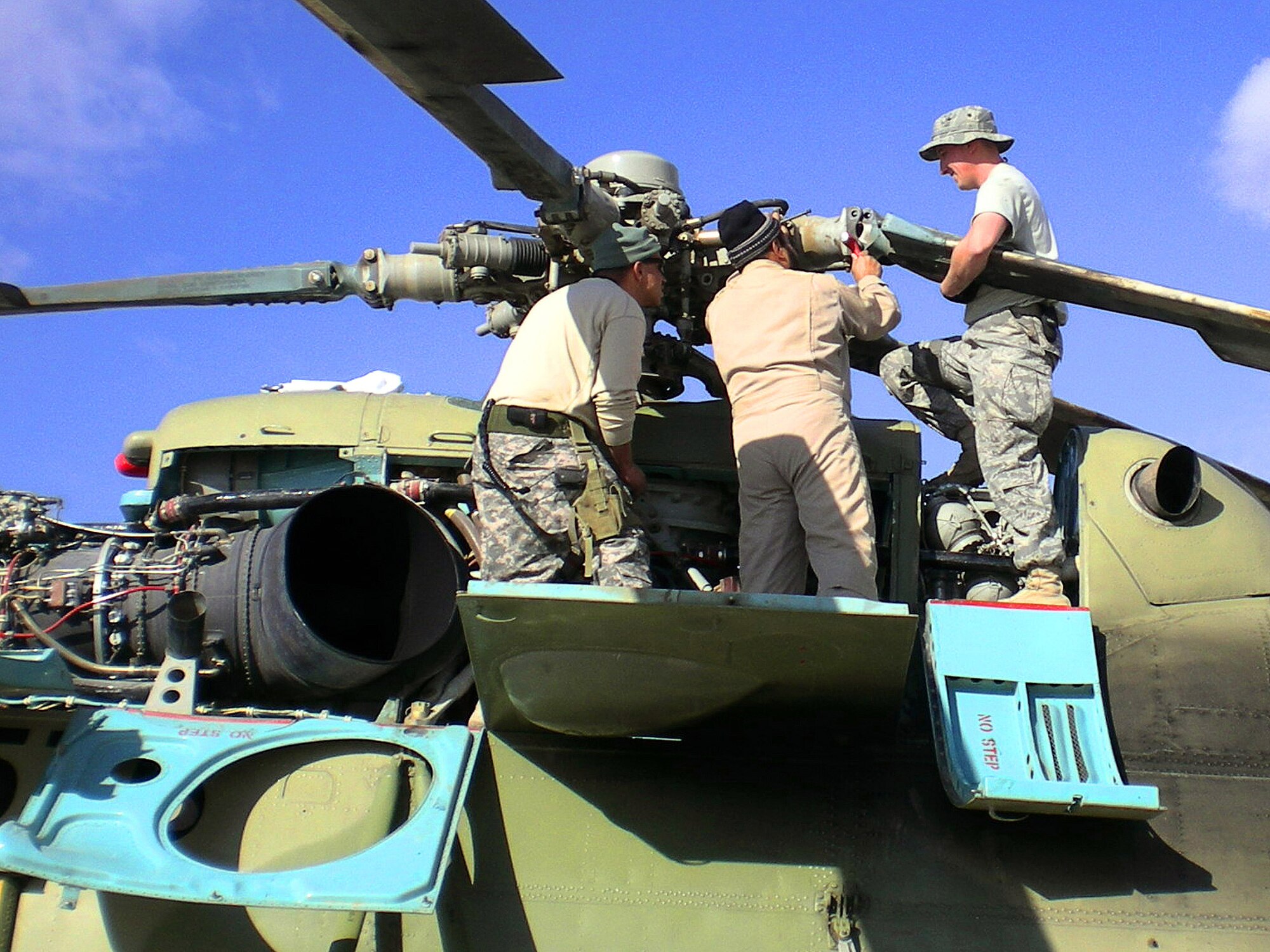 Tech. Sgt. Dennis Flanagan advises Afghan air corps maintainers on the Russian-made MI-17 transport helicopter March 2 at Kandahar Air Base, Afghanistan. Sergeant Flanagan is assigned to the 718th Aircraft Maintenance Squadron from Kadena Air Base, Japan. (Courtesy photo) 
