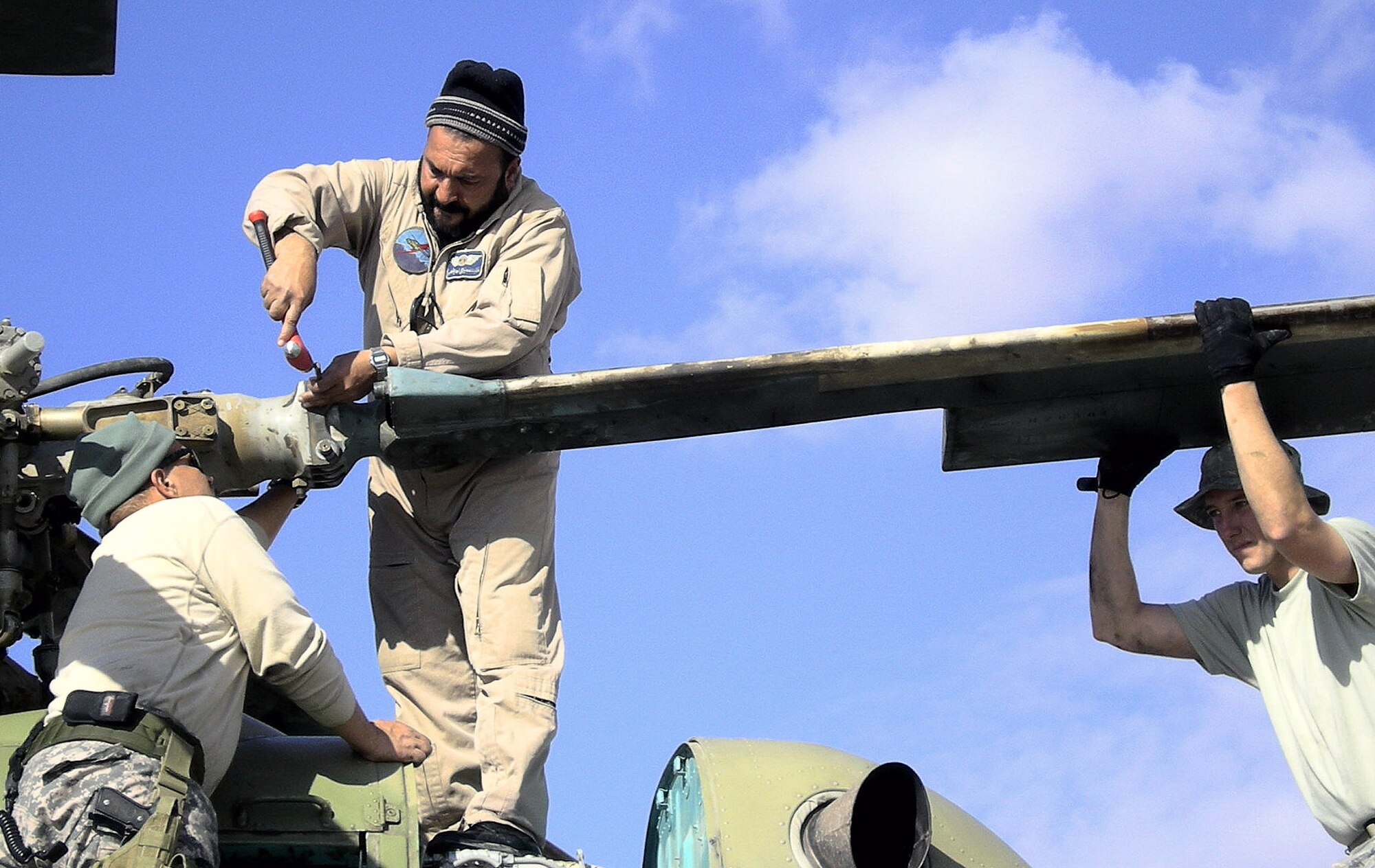 Tech. Sgt. Dennis Flanagan advises Afghan air corps maintainers on the Russian-made MI-17 transport helicopter March 2 at Kandahar Air Base, Afghanistan. Sergeant Flanagan is assigned to the 718th Aircraft Maintenance Squadron from Kadena Air Base, Japan. (Courtesy photo) 
