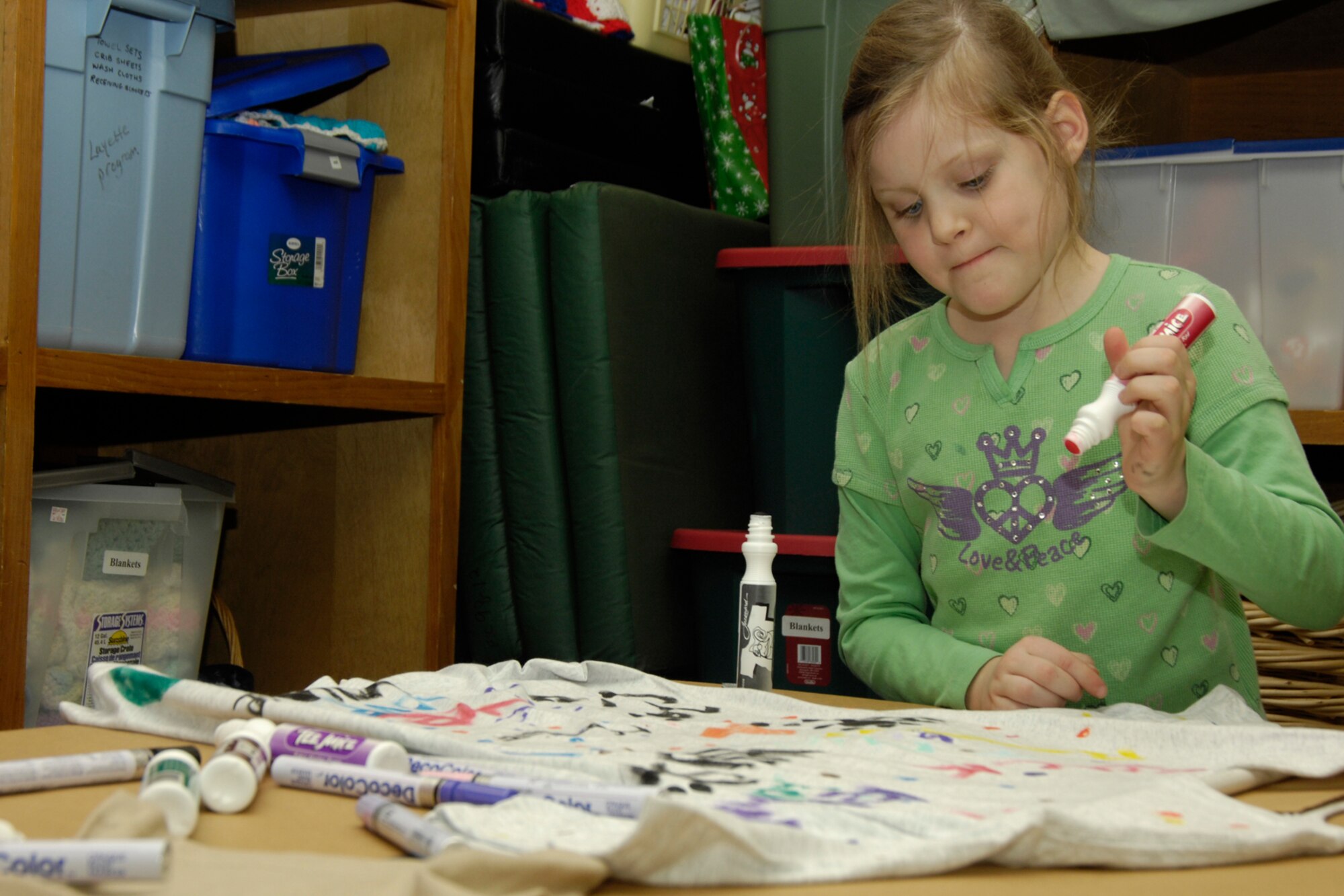 HANSCOM AIR FORCE BASE, Mass. – Kennedy Stone decorates a t-shirt to send to her deployed parent during the Hearts Apart family activity that took place at the Airman and Family Readiness Center on Feb. 26. The Hearts Apart program offers support and activities for families that have loved ones deployed. For more information on the program contact the A&FRC at (781) 377-4222.  (U.S. Air Force photo by Linda LaBonte Britt)