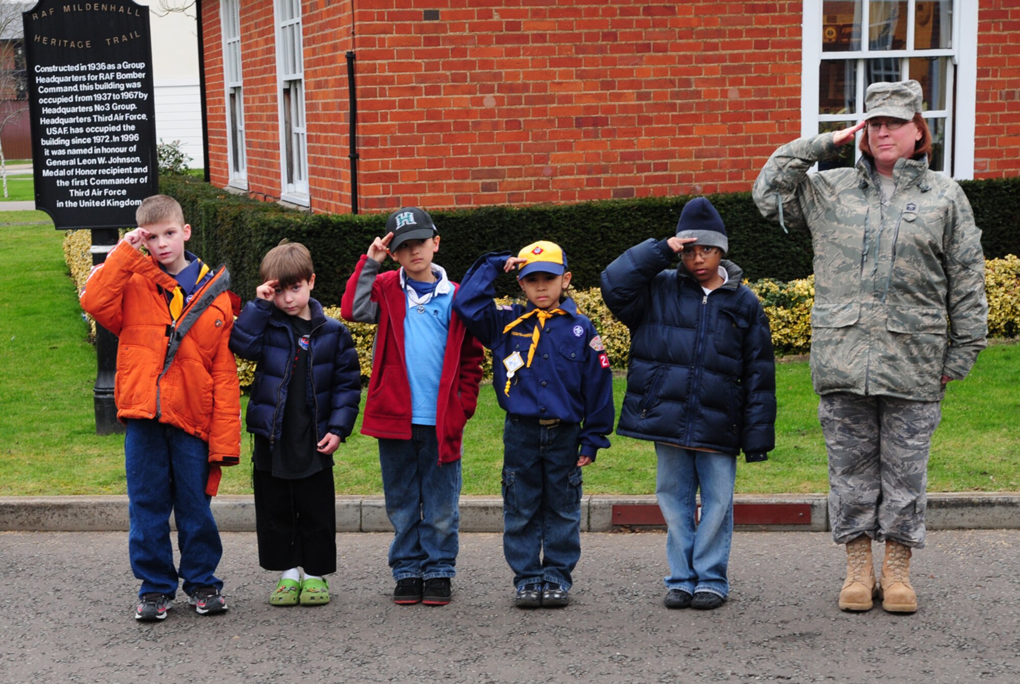 Cub Scouts from Pack 215, Wolf Den, salute during the playing of the national anthems Feb. 27, 2009, when members from the 100th Communications Squadron performed the Retreat ceremony. From left to right, Dustin Kelly, 7; Ben Stone, 7; Keoni Yonamine-Garcia, 8; Draégen Umiat, 8; Avery Holden, 9, and Senior Master Sgt. Diana Dillard, 100th CS, pay their respects as two honor guard members lower the American flag. (U.S. Air Force photo by Karen Abeyasekere)