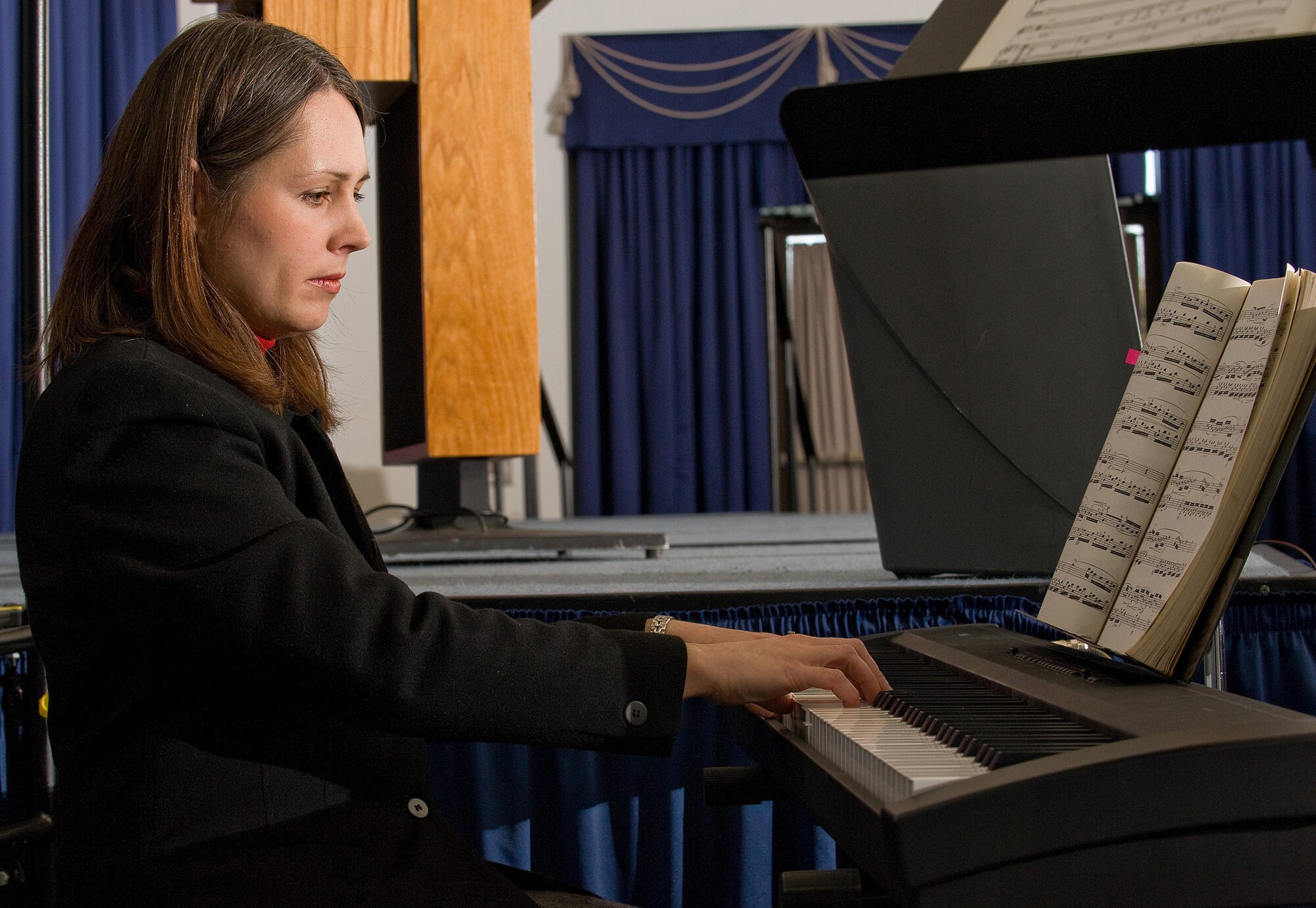 Deb Rojas, wife of Chaplain (Capt.) Richard Rojas, 436th Airlift Wing chaplain, played hymns and classical music during the National Prayer Luncheon Feb. 24 at the Landings Club. (U.S. Air Force photo/ Airman 1st Class Shen-Chia Chu)
