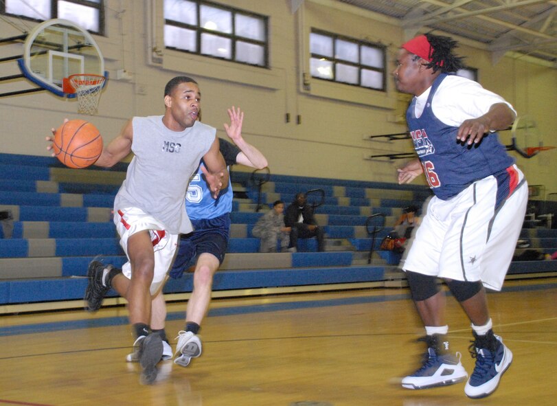 Rhonnell Singleton, 436th Force Support Squadron, sprints toward Ray Jones, 436th Medical Group, attempting to make a lay up during a basketball game Feb. 24 at the Fitness Center. (U.S. Air Force photo/ Airman 1st Class Shen-Chia Chu)