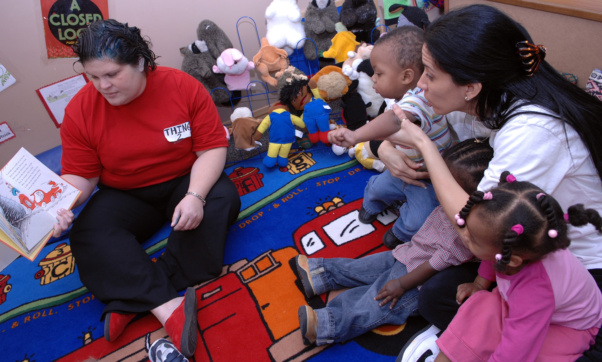 Jeannie Gooch, Incirlik Child Development Center director dressed as “Thing 2,” reads the book “Green Eggs and Ham” by Dr. Seuss to a group of one- to two–year-old children, March 2 at the Child Development Center’s “Seussentenial.” The Seussentenial is a celebration of author Dr. Seuss’ 100th Birthday if he were alive today by feeding the children green eggs and ham for breakfast as well as reading them a few of Dr. Seuss’ books. (U.S. Air Force photo/Senior Airman Erica Stewart)