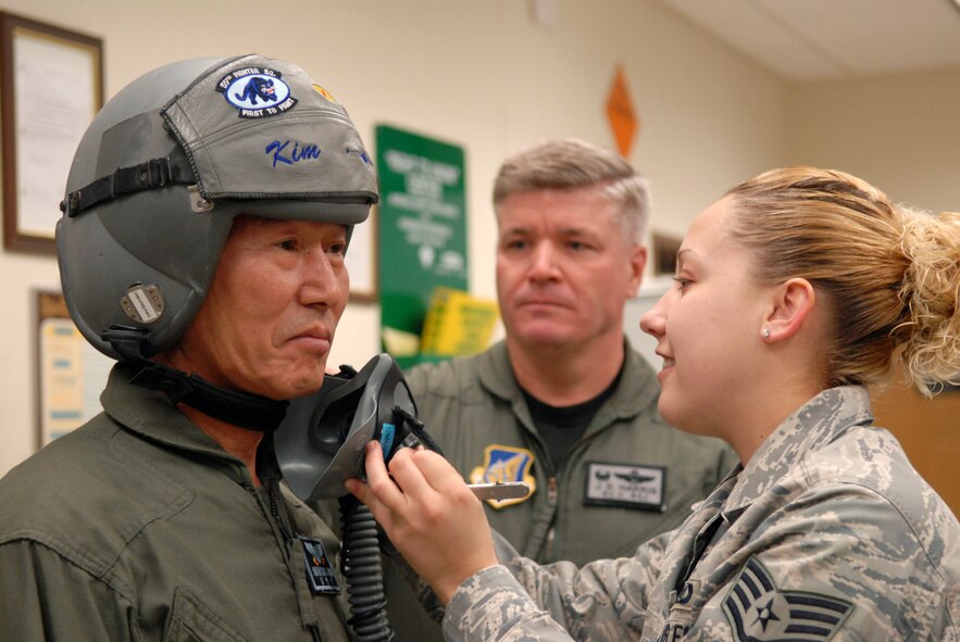 Kim Myung Jung, Gunsan City's Korean National Police Chief, is fitted for a oxygen mask by Staff Sgt. Kimberly Gage, 8th Operations Support Squadron, aircrew flight equipment technician, at Kunsan Air Base, Republic of Korea, March 4, 2009. Mr. Kim is participating in the base's Pilot for a Day program which is part of USFK's Good Neighbor Program. (U.S. Air Force photo by: Senior Airman Angela Ruiz)