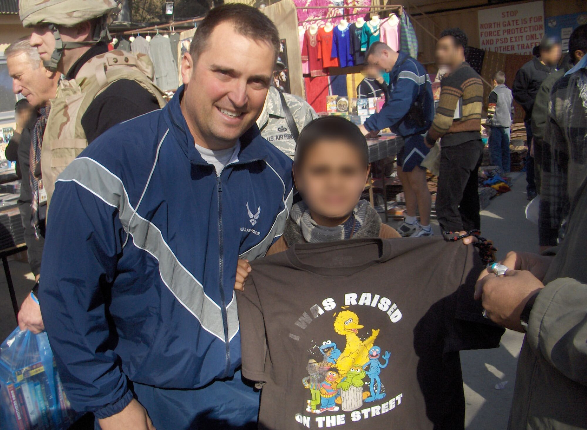 Capt. Matt Laubacher recently returned to Arnold Engineering Development Center from a six-month deployment to Afghanistan. While he was deployed, he had the opportunity to interact with the Afghans. Here, he gives an Afghan child, from whom he purchased items at the local bazaar, a Sesame Street T-shirt his mother sent him while at predeployment training in Wisconsin. (Photo provided)