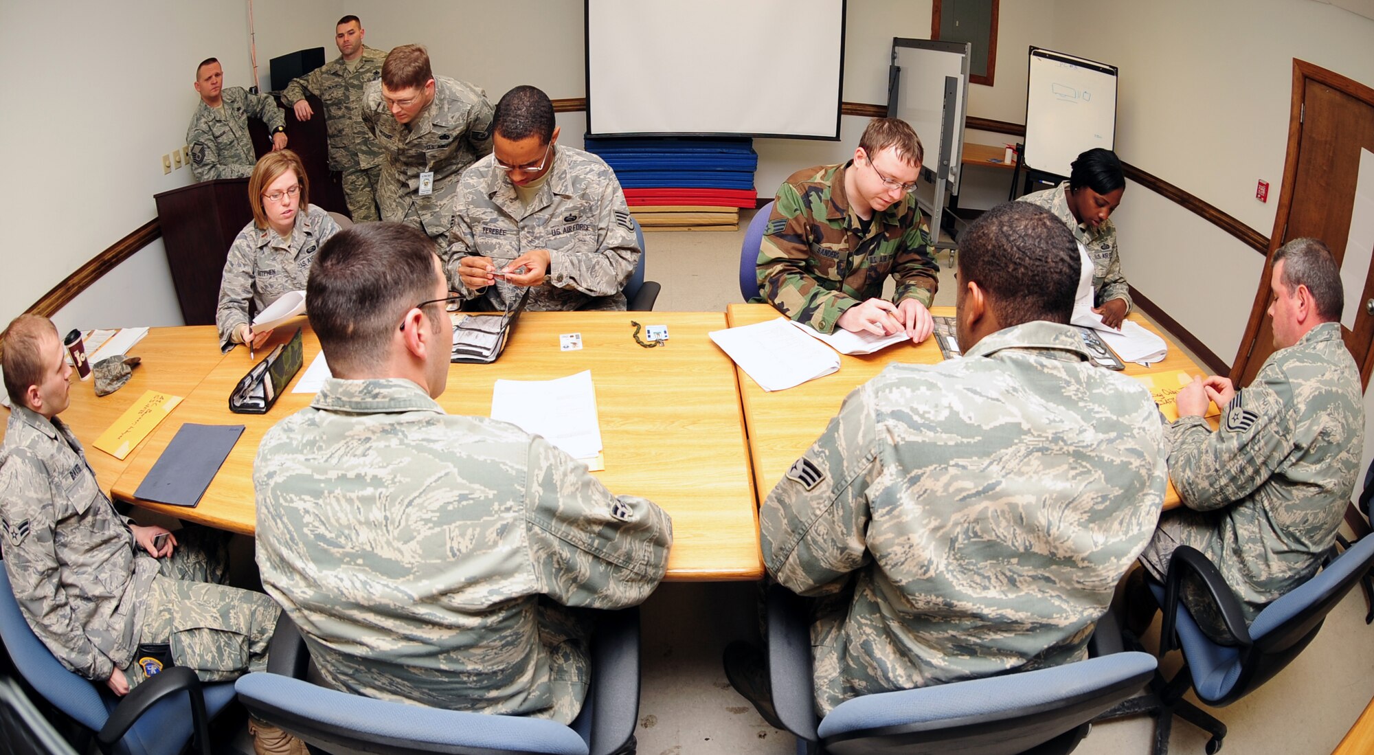 Members of the 4th Security Forces Squadron sit in front of supervision and members from the 4th Military Personnel Element while completing the out-processing paperwork at Seymour Johnson Air Force Base, N.C. For many of the Airmen at this table, it's at least their second deployment. (U.S. Air Force Photo by Airman 1st Class Rae A. Perry)