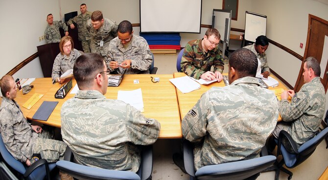 Members of the 4th Security Forces Squadron sit in front of supervision and members from the 4th Military Personnel Element while completing the out-processing paperwork at Seymour Johnson Air Force Base, N.C. For many of the Airmen at this table, it's at least their second deployment. (U.S. Air Force Photo by Airman 1st Class Rae A. Perry)