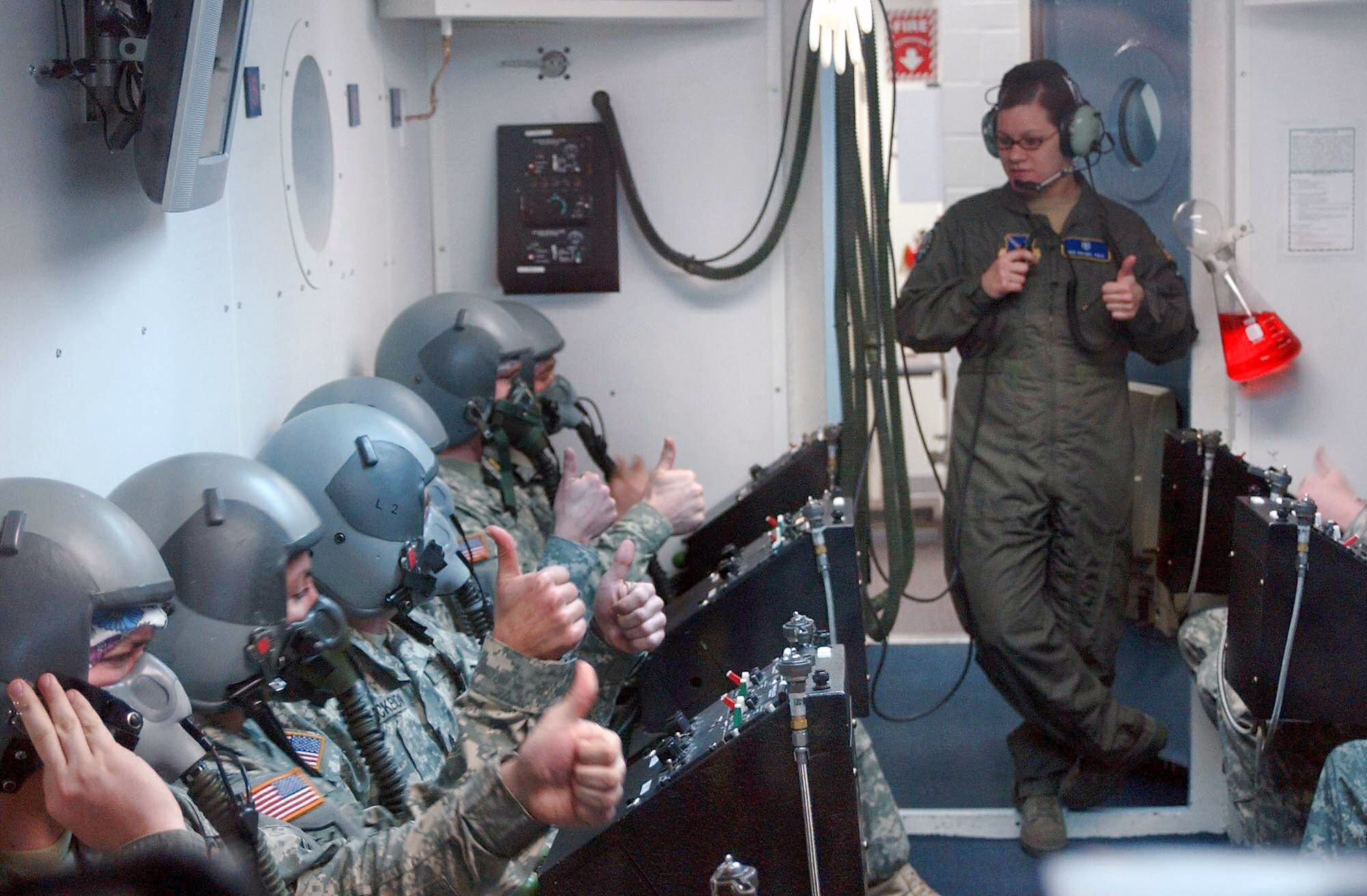 Senior Airman Rachel Cole makes a last minute breathing apparatus check on New York and Virginia National Guardsmen before sealing the oxygen chamber during high-altitude training at Andrews Air Force Base, Md., Feb. 25. (U.S. Army photo/Sgt. 1st Class Steven Petibone)