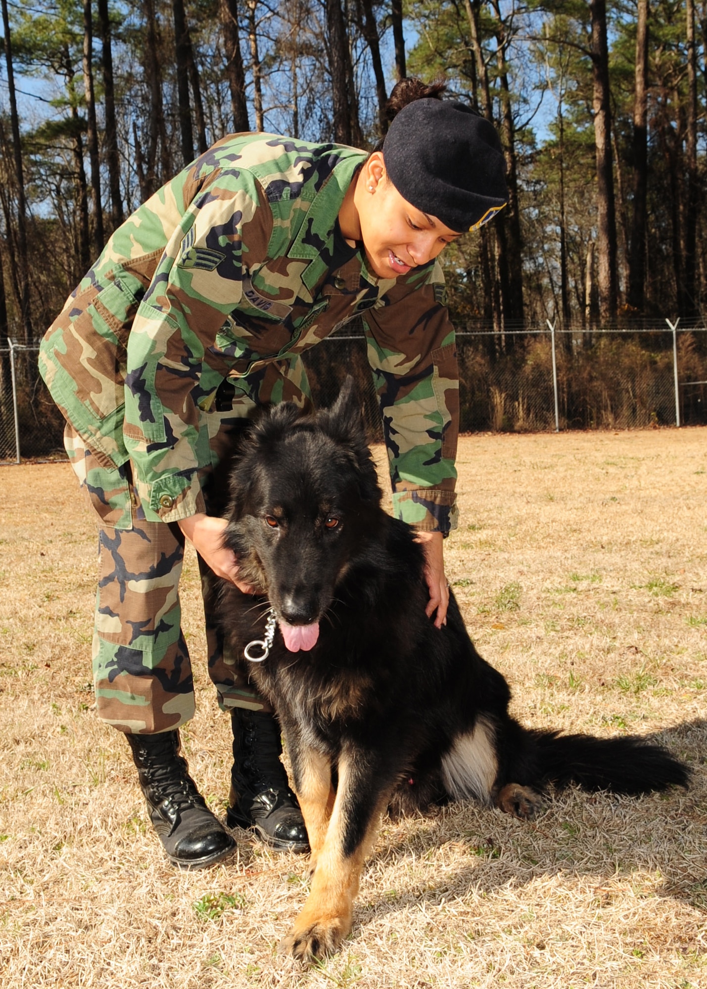Senior Airman Ava Davis, 4th Security Forces Squadron, praises her military working dog, Frisco, for a job well done after a run through the obstacle course here at Seymour Johnson Air Force Base, N.C. March 4, 2009. Airman Davis and Frisco were named outstanding performers during the 916th Air Refueling Wing’s Nuclear Operational Readiness Inspection by the Air Mobility Command Inspector General that took place a few weeks ago.  (U.S. Air Force Photo by Airman 1st Class Rae A. Perry)