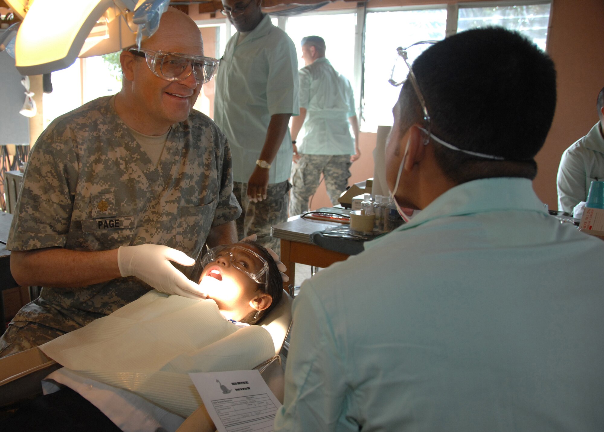 Maj. Greg Page and Staff Sgt. Hector Patino share a laugh with a Honduran boy they are performing a dental examination for at the Lions Club in Comayagua, Honduras, Feb. 24, in support of a dental readiness training excercise here.  The DENTRETE is a part of Beyond the Horizon, a humanitarian assistance exercise taking place throughout Central America. (U.S. Army photo by Spc. Christopher Wellner)