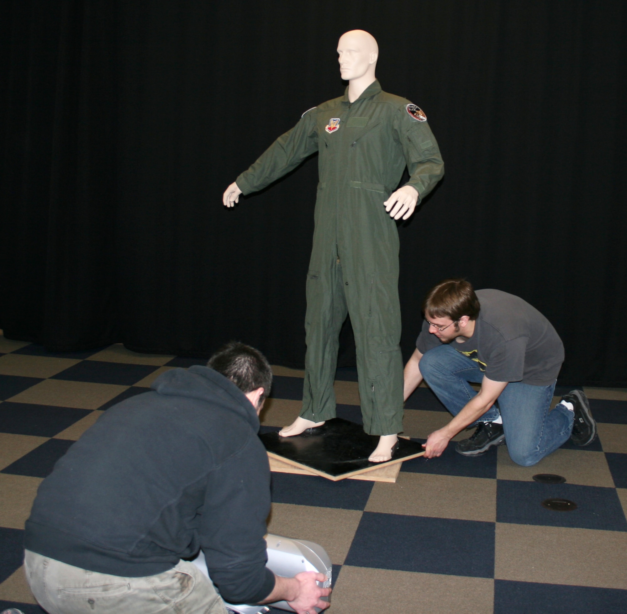 Brenton Mathews and David Pent, employees of Activision subsidiary Raven Software, position a mannequin with a flight suit from the 115th Fighter Wing in order to get a 3-D scan for use in current and possible future video games. Raven Software tries to scan authentic gear for use in their games to save artist time and also to extract a very high level of detail and authenticity for their games. (U.S. Air Force photo by Staff Sgt. Jon LaDue)