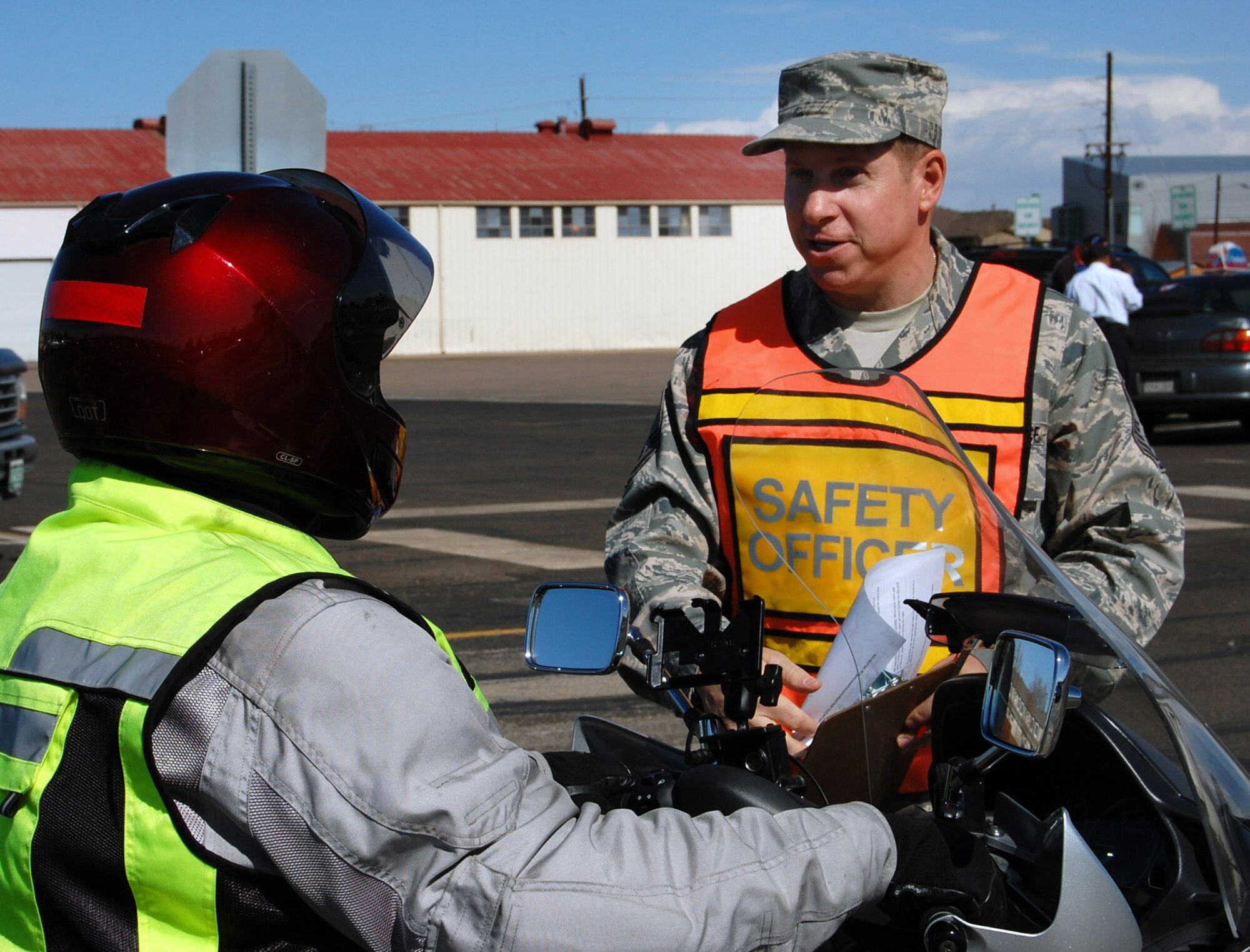 Master Sgt. William Caskey (right), ground safety manager at the Air Reserve Personnel Center, talks to Tom Sorg, during a seatbelt, cell phone and motorcycle survey at the Buckley Annex. The surveys are conducted to ensure Airmen and civilian employees at the Annex are staying safe by using seatbelts, not using cell phones without a hands-free device, and wearing the required equipment while riding a motorcycle. (U.S. Air Force photo/Ellen Edwards)