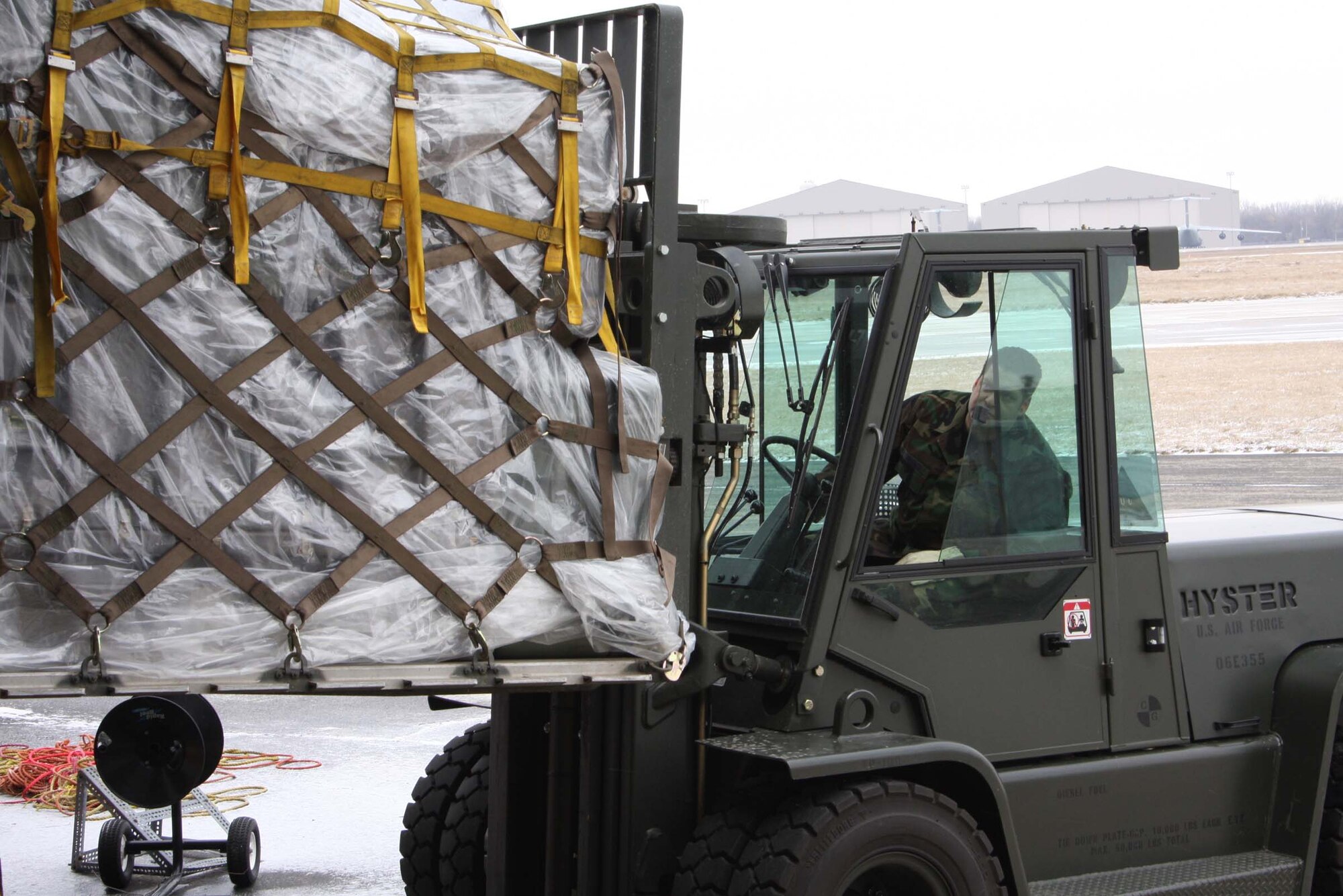 WRIGHT-PATTERSON AFB, Ohio – Senior Airman Russ Hernandez, 87th Aerial Port Squadron, maneuvers a fork lift to pick up a pallet recently built as part of a pallet building training scenario. The unit is preparing for a deployment this spring.  Once the pallets were built they were moved with a fork lift to another location. (Air Force photo/Senior Airman Ken LaRock) 