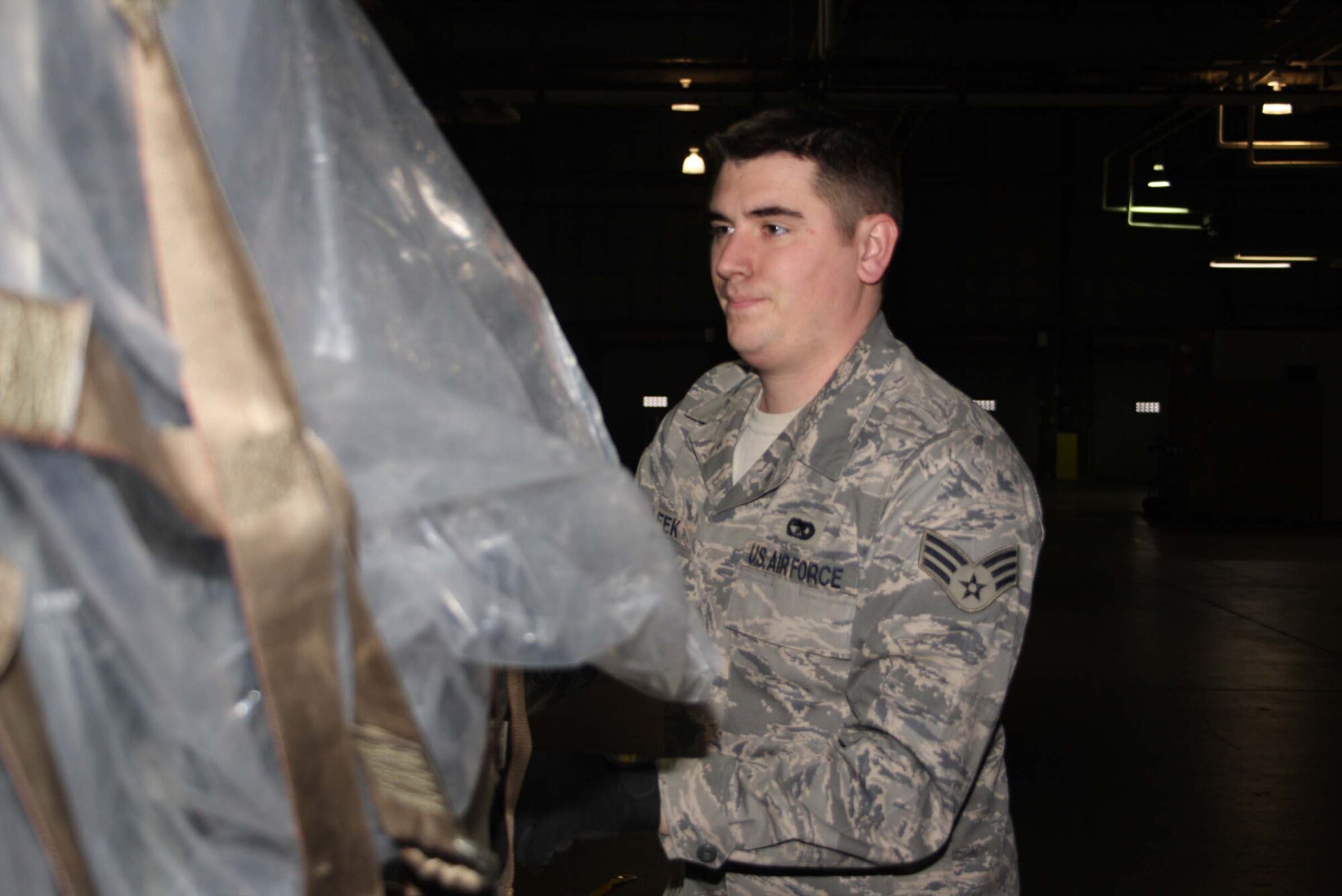 WRIGHT-PATTERSON AFB, Ohio – Senior Airman Michael Leek, 87th Aerial Port Squadron, puts the final touches on a pallet he and his fellow team members built during a pallet building training scenario. Once the pallets were built, they were moved with a fork lift to another location.  The unit is preparing for a deployment this spring.  (Air Force photo/Senior Airman Ken LaRock) 