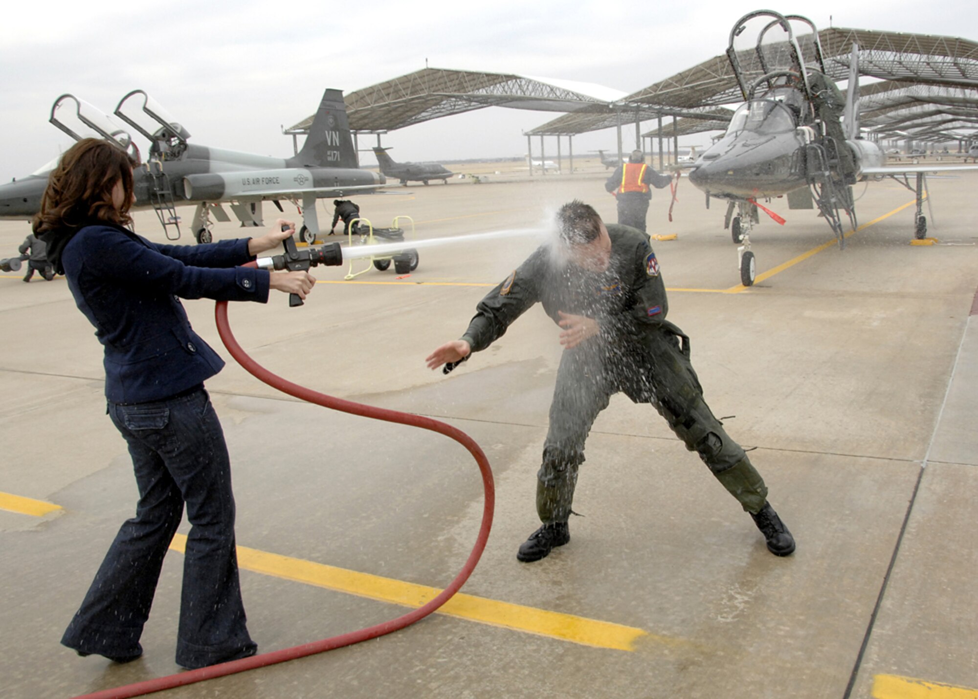 Capt. Robert M. Burgon, the first Vance T-38 First Assignment Instructor Pilot to receive an F-22 Raptor assignment, is hosed down after his fini-flight March 3 in a 25th Flying Training Squadron T-38 by his girlfriend, XXXXXXXXXXXX. Captain Burgon, from Ogden, Utah, is heading for Tyndall AFB, Fla., for training to fly the F-22. He is a graduate of Vance’s class 05-13 and served as a T-38 FAIP here from January 2006 to September 2008. (U.S. Air Force photo by Terry Wasson)