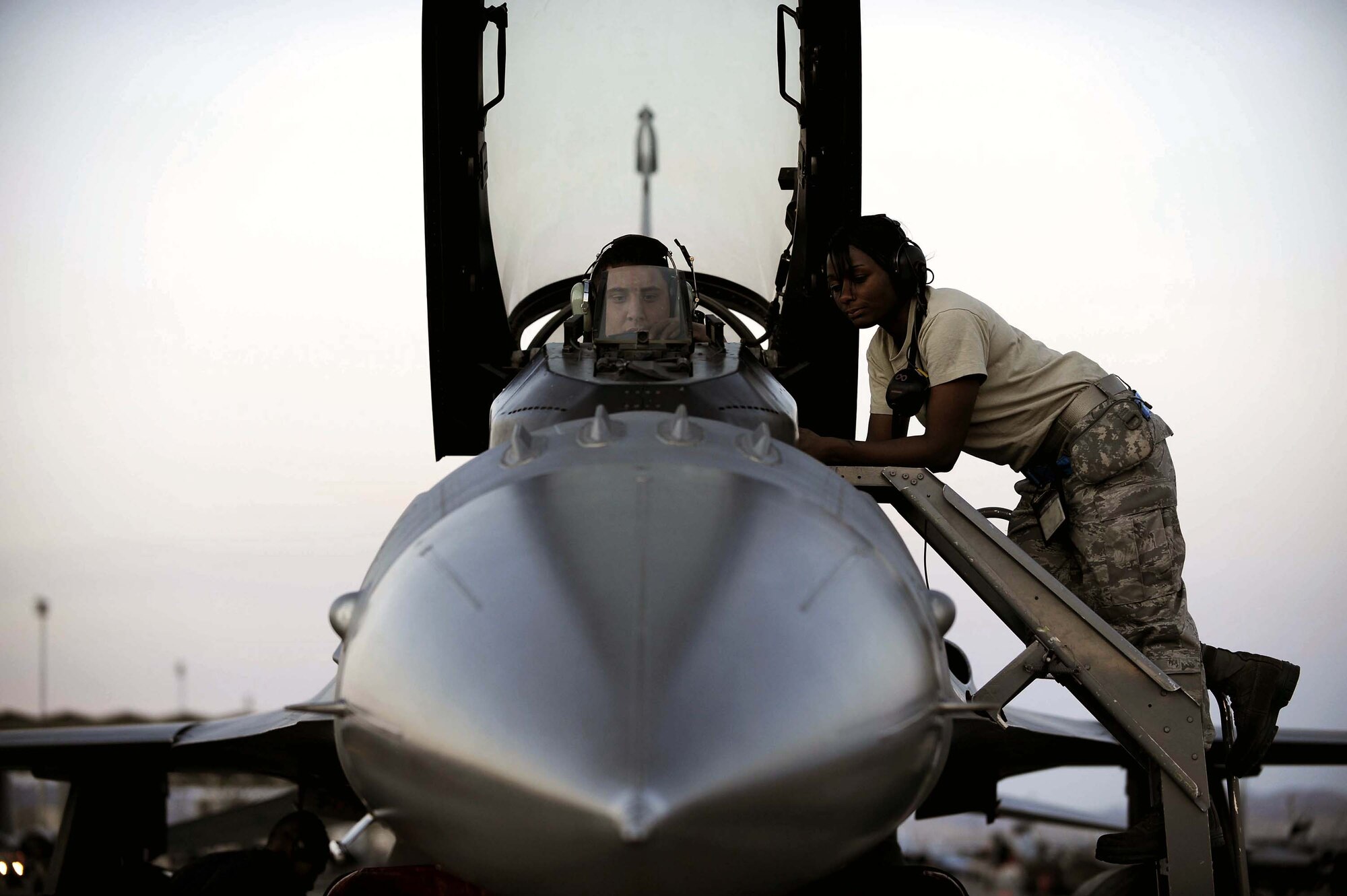 Senior Airman Alden Gehrt sits in the cockpit of an F-16 Fighting Falcon and Staff Sgt. Tarha Mazyck conduct routine system maintenance before night flying operations during Red Flag 09-3 Feb. 26 at Nellis Air Force Base, Nev. Red Flag is a multinational exercise providing a realistic environment to practice combat scenarios. Airman Gehrt is an avionics apprentice and Sergeant Mazyck is an an avionics craftsman. Both are deployed here from the 52nd Aircraft Maintenance Squadron at Spangdahlem Air Base, Germany. (U.S. Air Force photo/Senior Airman Larry E. Reid Jr.) 
