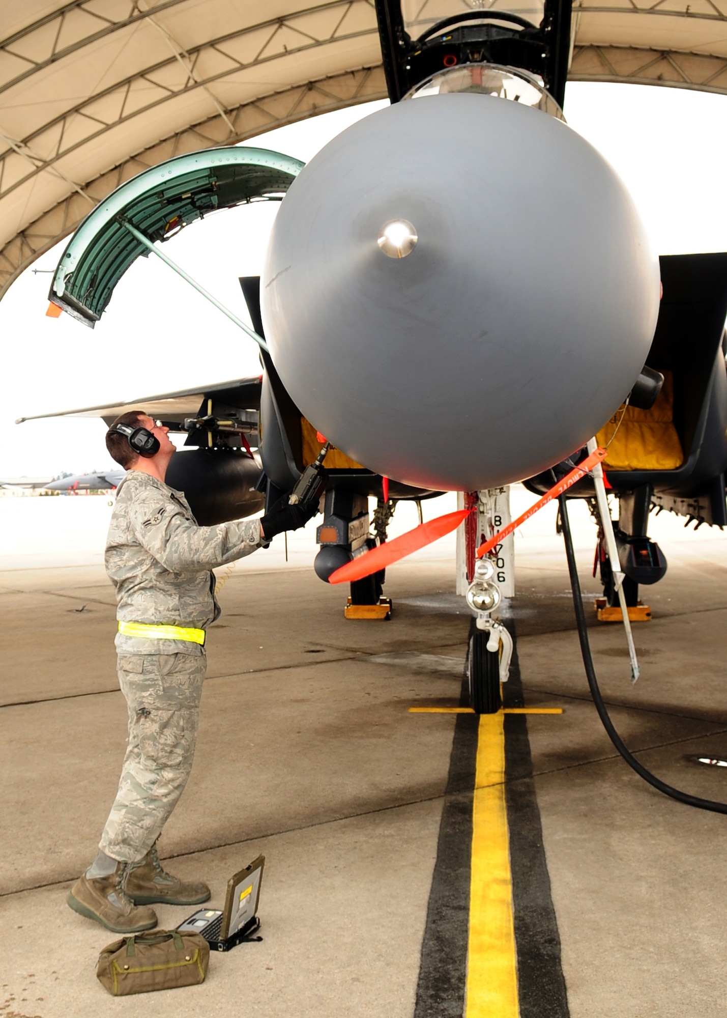 Airman 1st Class Michael Strombelline, 336th Aircraft Maintenance Squadron, checks the electrical systems of an F-15E Strike Eagle during a power-on test conducted under the flightline shelters at Seymour Johnson Air Force Base N.C., March 2. The shelters were designed to minimize sun damage to the aircraft and minimize the amount of rain that reaches the aging aircraft. (U.S. Air Force Photo by Airman 1st Class Rae A. Perry)