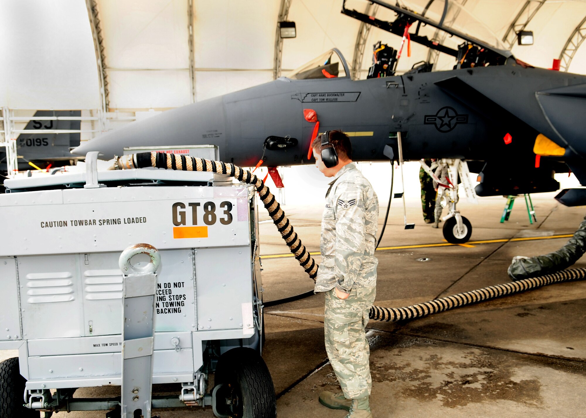 Senior Airman Jon Meyers, 336th Aircraft Maintenance Squadron, powers on a generator used to run the electrical systems of an F-15E Strike Eagle under a new flight line shelter at Seymour Johnson Air Force Base N.C., March 2. Shelters on the flightline are used to prevent weather damage to the jets. (U.S. Air Force Photo by Airman 1st Class Rae A. Perry)