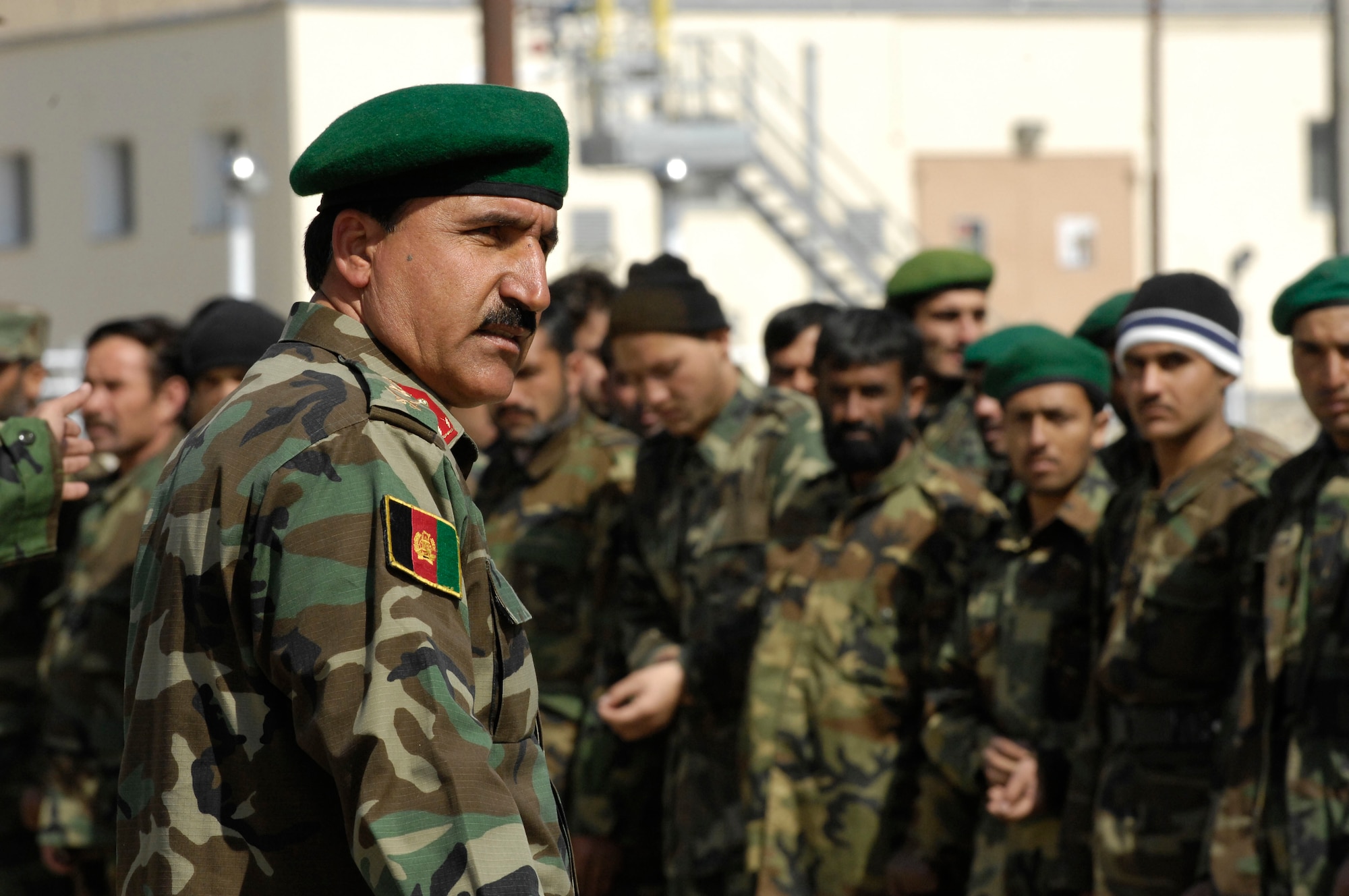 Afghanistan National Army Lt. Col. Ghulan Mohadeen, Class III Fuels Depot deputy commander, awaits the arrival of Afghan Assistant Defense Minister Lt. Gen. Jawhari, chief of acquisition, technology and logistics, with a formation of ANA soldiers. The ANA hosted an inaugration Feb. 28 of the Khuja Rawash Class III Fuels Depot in Kabul. (U.S. Air Force photo/ Maj. Carie A. Parker)(Released)
