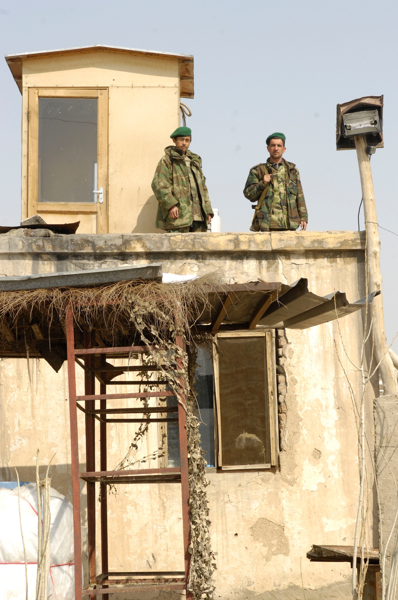 Afghanistan National Army soldiers stand atop a security tower Feb. 17 at Khair-Khana, a primitive Soviet-era fuels facility, built around 1977, with a manual, gravity-fed system without electricity or pumps. The soldiers live in the building below when not on duty. Airmen from the 755th Air Expeditionary Group, Logistics Embedded Training Team, Combined Security Transition Command - Afghanistan, assisted the ANA in transitioning from the outdated facility to a state-of-the-art class III fuel depot. (U.S. Air Force photo/ Maj. Carie A. Parker)(Released)
