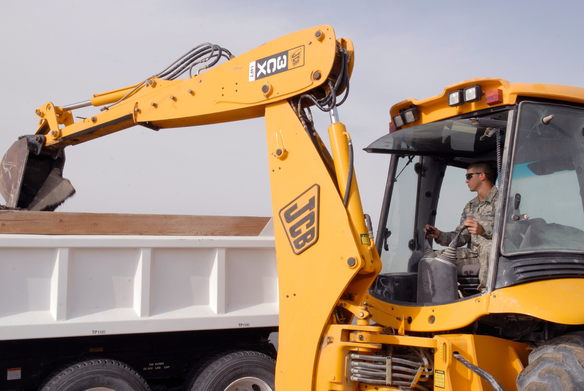 Airman 1st Class Andrew Sanders, a 379th Expeditionary Civil Engineer Squadron Pavements and Equipment Journeyman, dumps broken asphalt with a backhoe in preparation for a patch repair on the flightline, Mar. 4, 2009, at an undisclosed location in Southwest Asia.  Airman Sanders hails from Payson, Ariz. and is deployed from Spangdahlem Air Base, Germany in support of Operations Iraqi and Enduring Freedom and Combined Joint Task Force - Horn of Africa.  (U.S. Air Force Photo by Senior Airman Andrew Satran/Released)