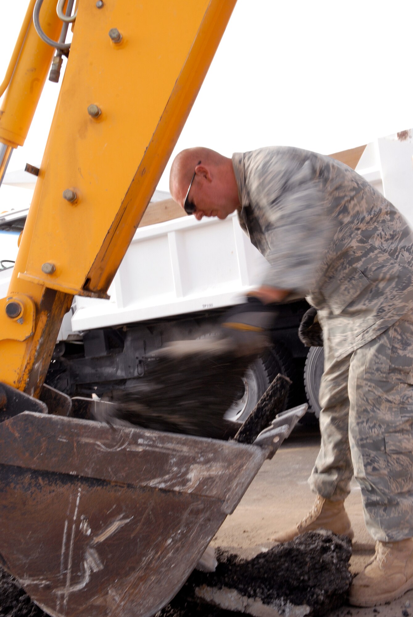 Staff Sergeant Byron Icenogle, a 379th Expeditionary Civil Engineer Squadron Maintenance and Equipment Operator, helps load asphalt dug up in preparation for a patch repair on the flightline, Mar. 4, 2009, at an undisclosed location in Southwest Asia.  Staff Sgt. Icenogle hails from Shelbyville, Ind. and is deployed from Scott Air Force Base, Ill., in support of Operations Iraqi and Enduring Freedom and Combined Joint Task Force - Horn of Africa.  (U.S. Air Force Photo by Senior Airman Andrew Satran/Released)
