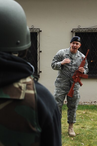 U.S. Air Force Senior Airman Christopher Bidwell, 569th U.S. Forces Police Squadron member, explains defense techniques during the Kids 4 Kids monthly event Feb. 27, 2009, at Ramstein Air Base. K4K is a monthly program for children with a deployed parent with events designed to help children understand better what their parent's do while deployed. (U.S. Air Force photo by Senior Airman Amber Bressler)