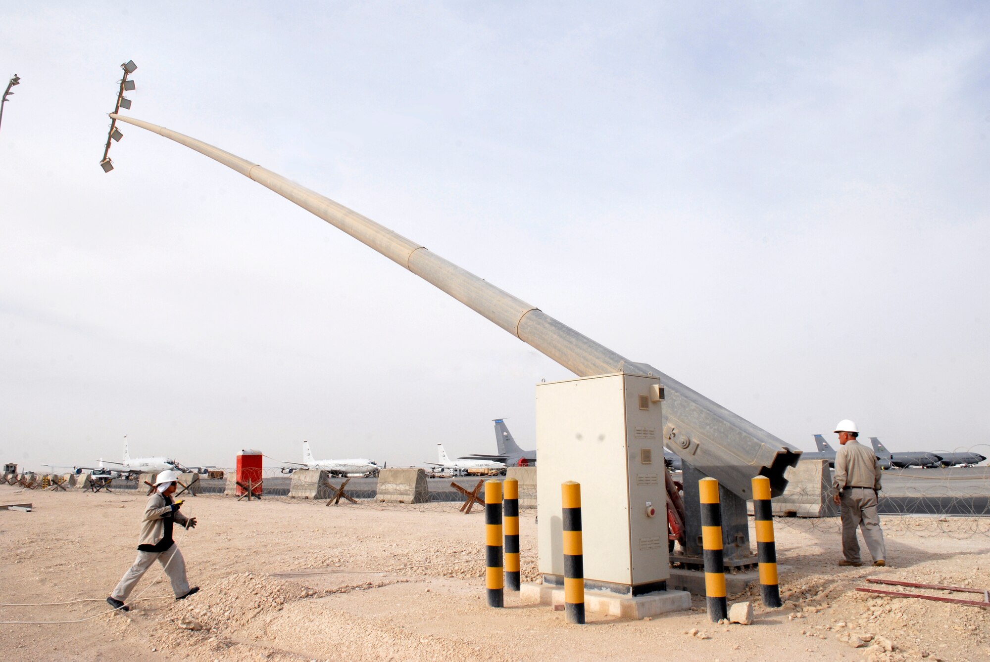 Jimmy Mercado and John Nettles, 379th Civil Engineer Squadron Readiness Management Support (RMS) Contractors, lower a ramp parking light tower on the outer edge of the flightline for repair, Mar. 4, 2009, at an undisclosed location in Southwest Asia.  Jimmy Mercado hails from Santa Rita Pampanga, Philippines.  John Nettles hails from McComb, Miss.  Both are here in support of Operations Iraqi and Enduring Freedom and Combined Joint Task Force - Horn of Africa.  (U.S. Air Force photo by Senior Airman Andrew Satran/released)