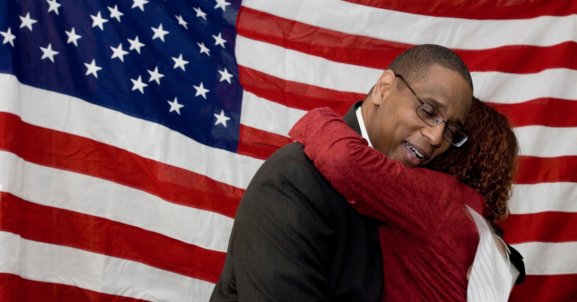 U.S. Citizenship and Immigration Services Field Office Director Elliott Cook embraces Mrs. Karen Villamor,  the newest naturalized U.S. citizen to recite the oath under his watch, Feb. 13, 2009. Mr. Cook traveled from the London office to perform the ceremony for Villamor at RAF Mildenhall, England. (U.S. Air Force photo by Master Sgt. Tracy L. DeMarco)