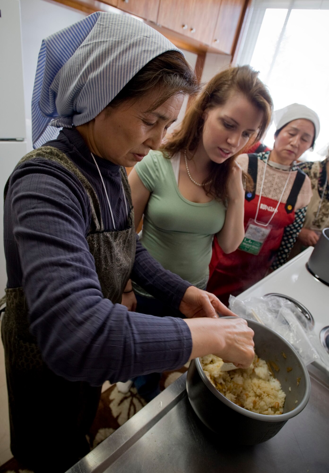 MISAWA AIR BASE, Japan -- Mitsue Sato shows Naomi Dames how to prepare a vegetable rice dish in the Miguel residence March 4, 2009. Ms. Dames and Michelle Miguel participated in a cultural exchange with members of the Tohoku Health and Diet Improvement Program. (U.S. Air Force photo by Staff Sgt. Samuel Morse)