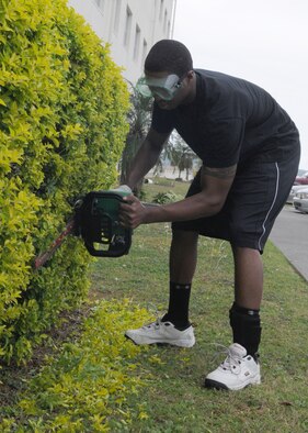 KADENA AIR BASE, Japan -- Airman 1st Class Donald Grant, 353rd Maintenance Squadron, trims the hedges in front of dormitory 758 here Feb. 28.  The dorm residents', who are predominately 353rd Special Operations Group and 18th Medical Group Airmen, won the base's last Dorm of the Quarter Award and the $2,000 that goes along with it. Before winning the competition, the residents were busy with several improvement projects that included the day rooms on the first three floors, and are in the process of renovating the fourth floor dayroom. (U.S. Air Force photo by Tech. Sgt. Aaron Cram)