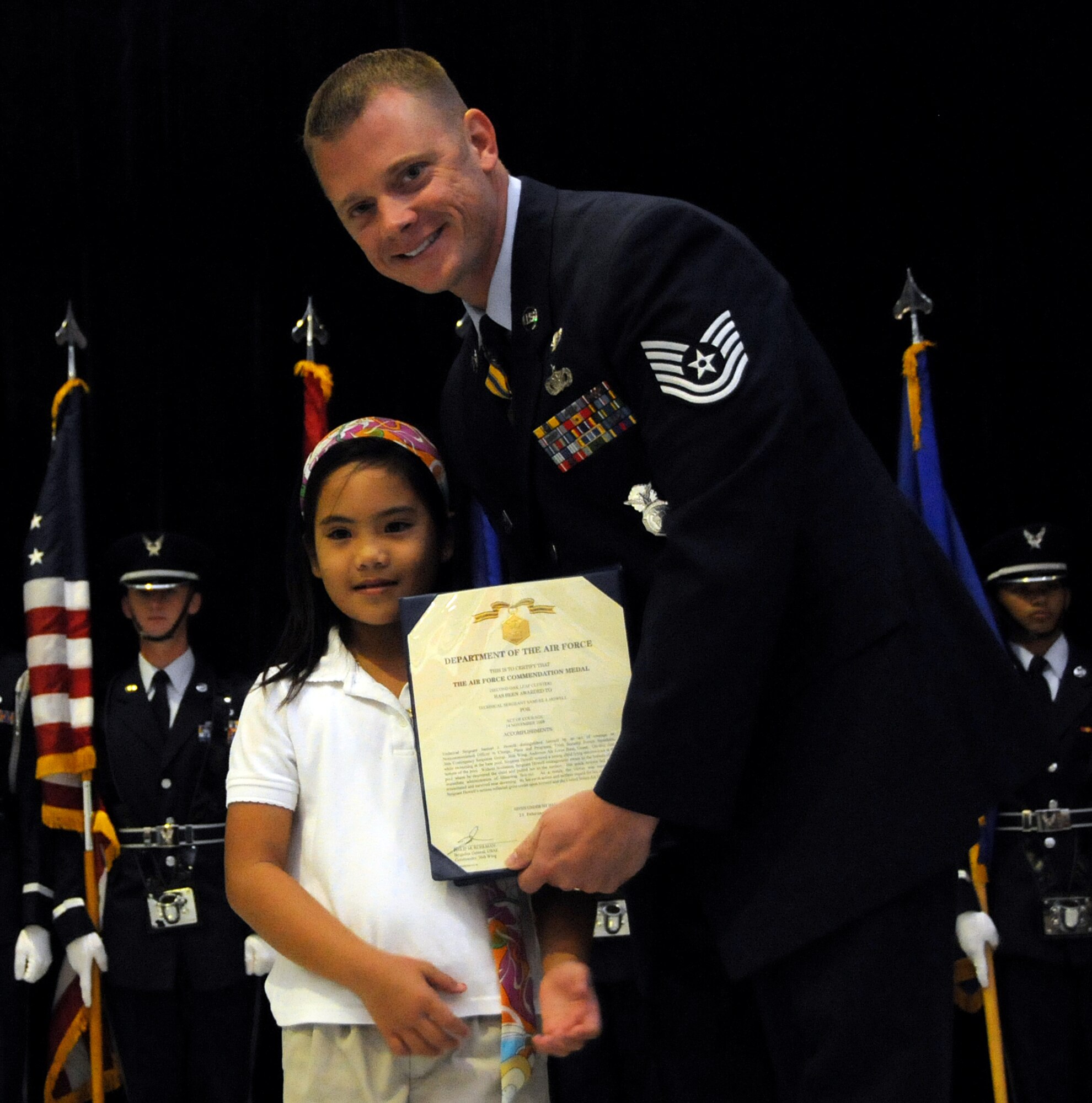 ANDERSEN AIR FORCE BASE, Guam - Jaeleen Jaylo presents Tech. Sgt. Sam Howell, 36th Security Forces Squadron, the Commodation for his heroic efforts during the Andersen Elementary School Awards Ceremony here March 4. The Air Force Commendation Medal may be awarded to members of the Armed Forces of the United States below the grade of Brigadier General who, while serving in any capacity with the Air Force, distinguish themselves by heroism, outstanding achievement, or by meritorious service not of a sufficient nature to justify a higher award. (U.S. Air Force photo by Airman 1st Class Courtney Witt)
