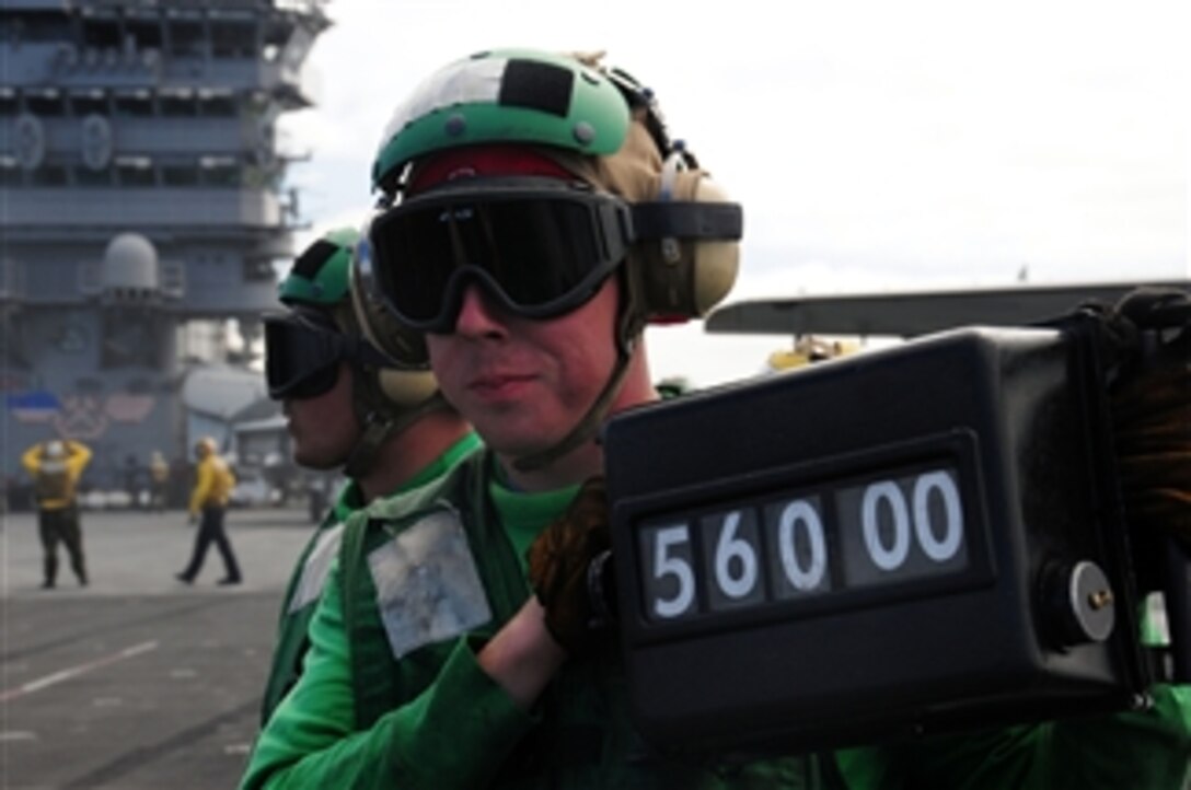 U.S. Navy Petty Officer 3rd Class Doug Bellew displays the weight of an F/A-18F Super Hornet aircraft to the catapult safety officer before takeoff from the flight deck of the aircraft carrier USS Nimitz (CVN 68) underway in the Pacific Ocean on Feb. 25, 2009.  The ship and Carrier Air Wing 11 are conducting tailored ship's training availability off the coast of Southern California.  