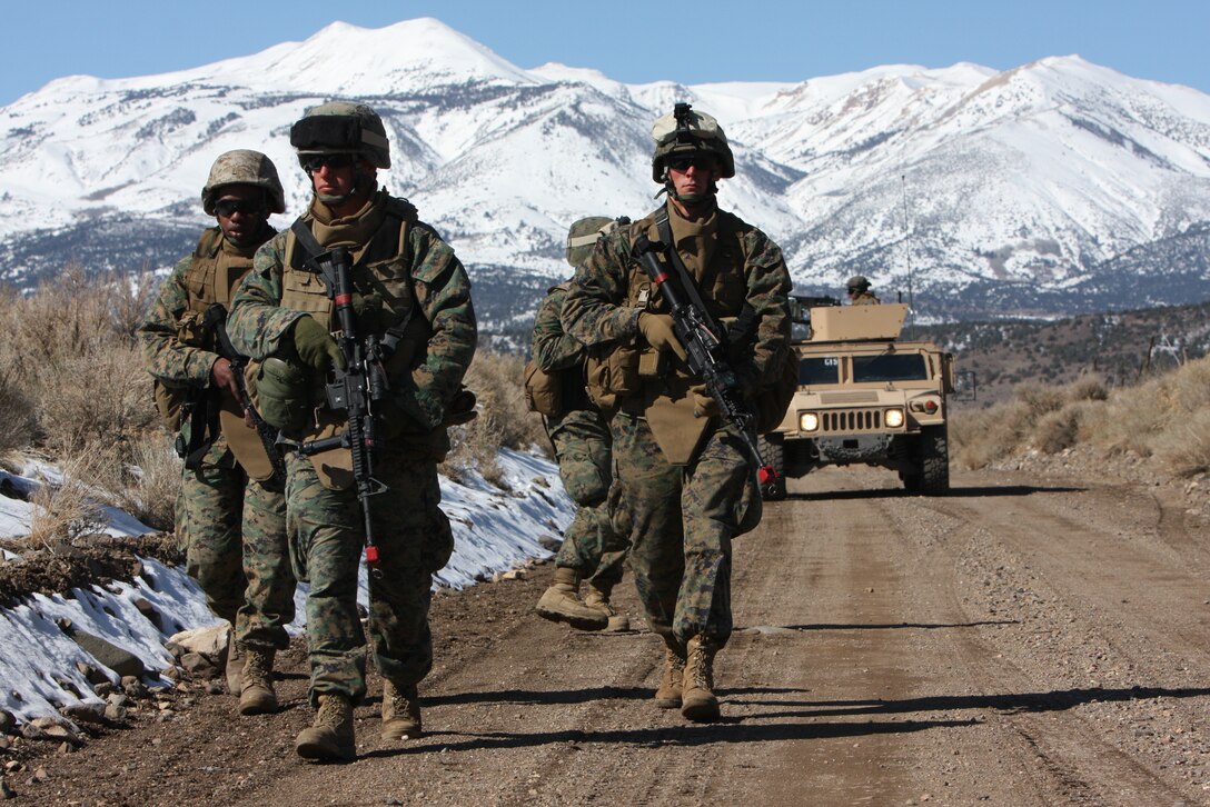 Four Marines of Weapons Company, 3rd Battalion, 4th Marine Regiment, dismount their vehicles and punch-out to provide unit security while fellow Marines notionally call the Explosive Ordinance Disposal team to investigate a mock IED during a convoy training exercise outside of Hawthorne Army Ammunition Depot in Hawthorne, Nev., March 7.
